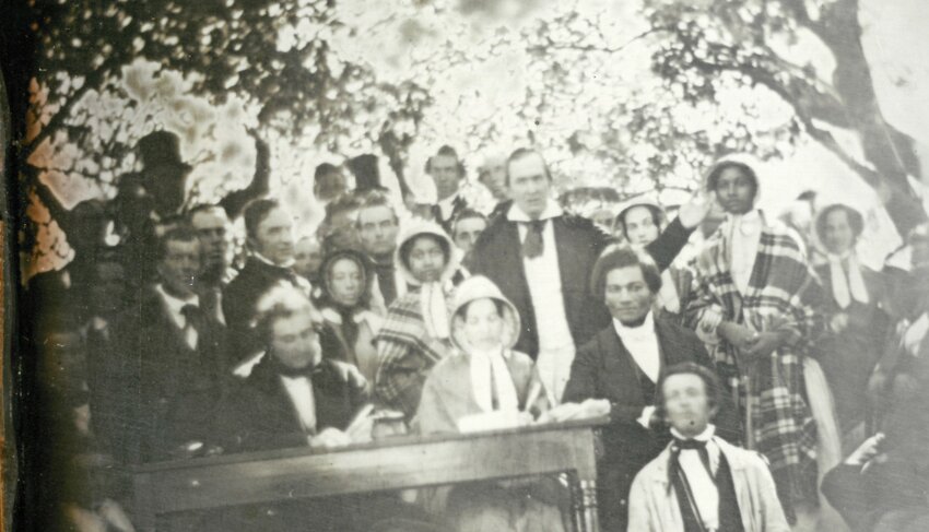 Daguerreotype by Ezra Greenleaf Weld of August 22, 1850 Anti Fugitive Slave Law Convention in Cazenovia, courtesy of Madison County Historical Society, Oneida. The two women in bonnets and patterned cloaks are Emily and Mary Edmonson. Frederick Douglass sits on the right at the table. Gerrit Smith stands with his arms raised behind Douglass.