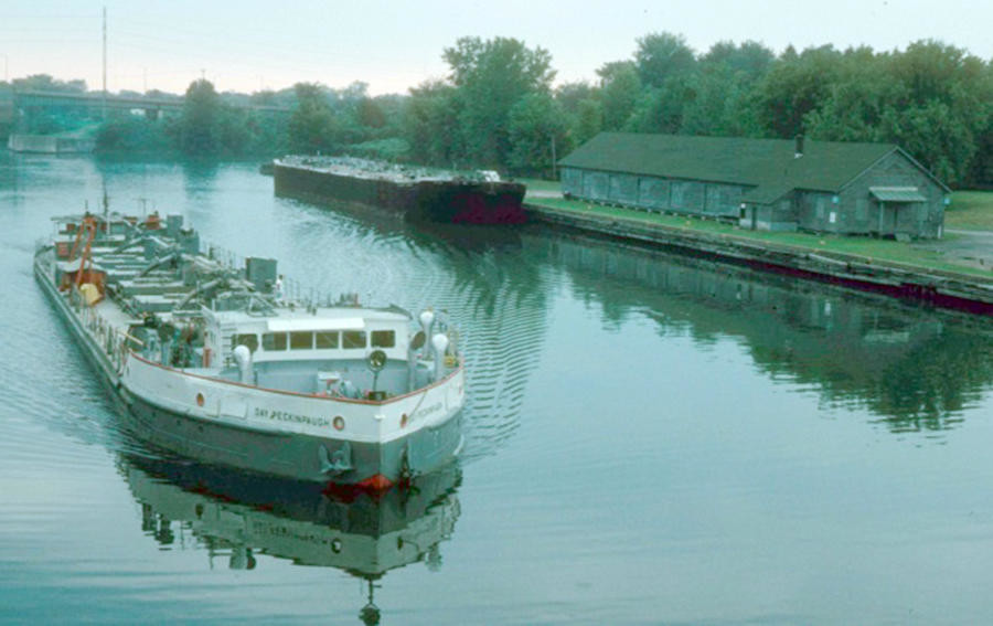 HEAVY HAULER — The ship Day Peckinpaugh makes its way through Rome on the Erie Canal, past what is now Bellamy Harbor Park. Named for the brother of a New York Yankees player, the ship is listed on the National Register of Historic Places, and is kept in Cohoes, where it is being restored.
 (Photo courtesy Canal Society of New York)