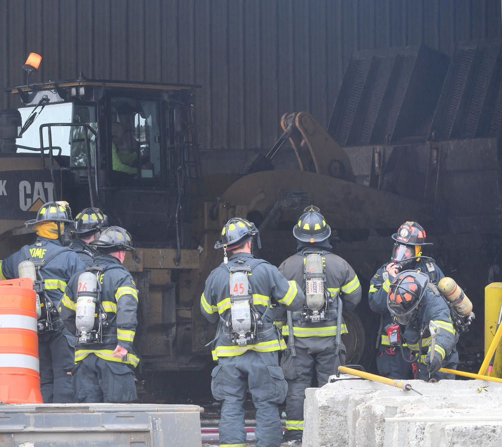 GEARING UP — Rome firefighters prepare to go inside the transfer station on Perimeter Road while a county-owned front loader moves around the burning garbage pile to reveal hot spots.
 (Sentinel photo by John Clifford)