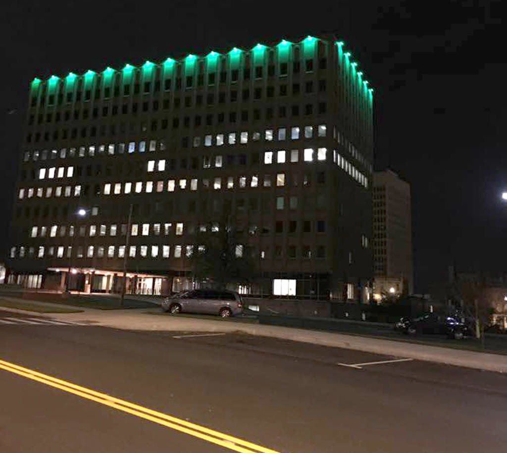 AWASH IN GREEN — Green lights glow from the top of the Oneida County Office Building, 800 Park Ave., to honor veterans on Thursday night, Nov. 10.  County Executive Anthony J. Picente Jr. is encouraging residents and businesses throughout the county to also use green lights to honor those who have served in the military.
 (Photo submitted)