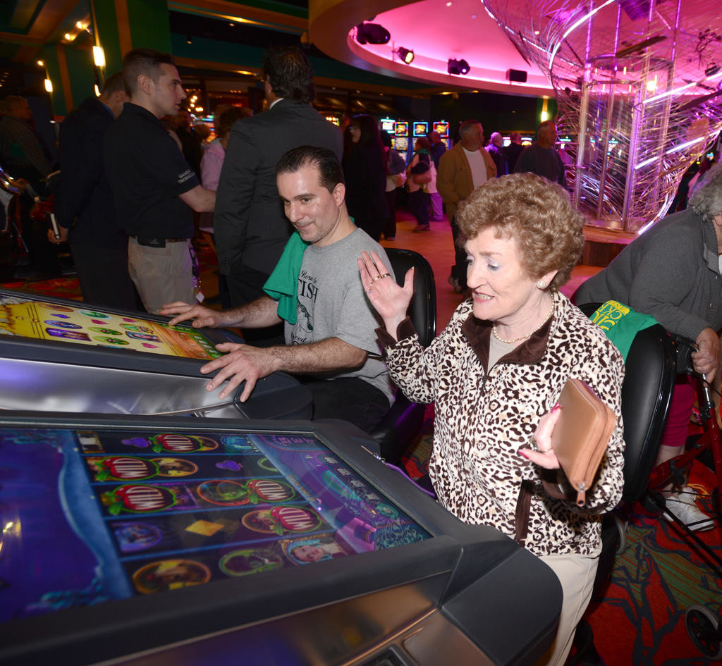 OVER THE RAINBOW — Anne Smith from Ireland reacts to her slot game at the Yellow Brick Road casino. Looking on is Charles Akins from Syracuse who was waiting since 11 p.m. the night before to start gaming.
 (Sentinel photo by John Clifford)