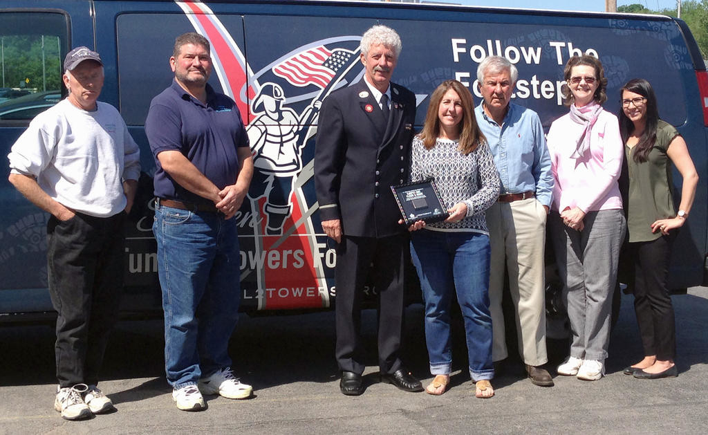 LOCAL BUSINESS RECOGNIZED — Meelan’s Carpet One Floor and Home of Yorkville on Thursday received a shadowbox containing 9/11 World Trade Center steel, in thanks for supporting the Stephen Siller Tunnel to Towers Foundation’s Building for America’s Bravest program. From left: Brian LaRock, warehouse manager; Frank Zammiello, installer; Brian Rowan, a retired Fire Department of New York City lieutenant; Kyra Meelan, president of Meelan’s Carpet One Floor and Home; Joe Meelan, CEO; Cathy Fauss, office manager; and Amanda Harter, sales associate.