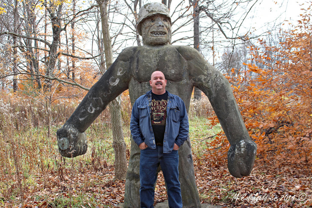 GIANT OF A MAN — Michael Colangelo, who runs a Facebook site called People and Places of Rome, NY, stands in front of the giant Alley Oop statue. Some followers of the Facebook site would like to see the statue preserved and displayed.
 (Photo courtesy Michael Colangelo Sr.)
