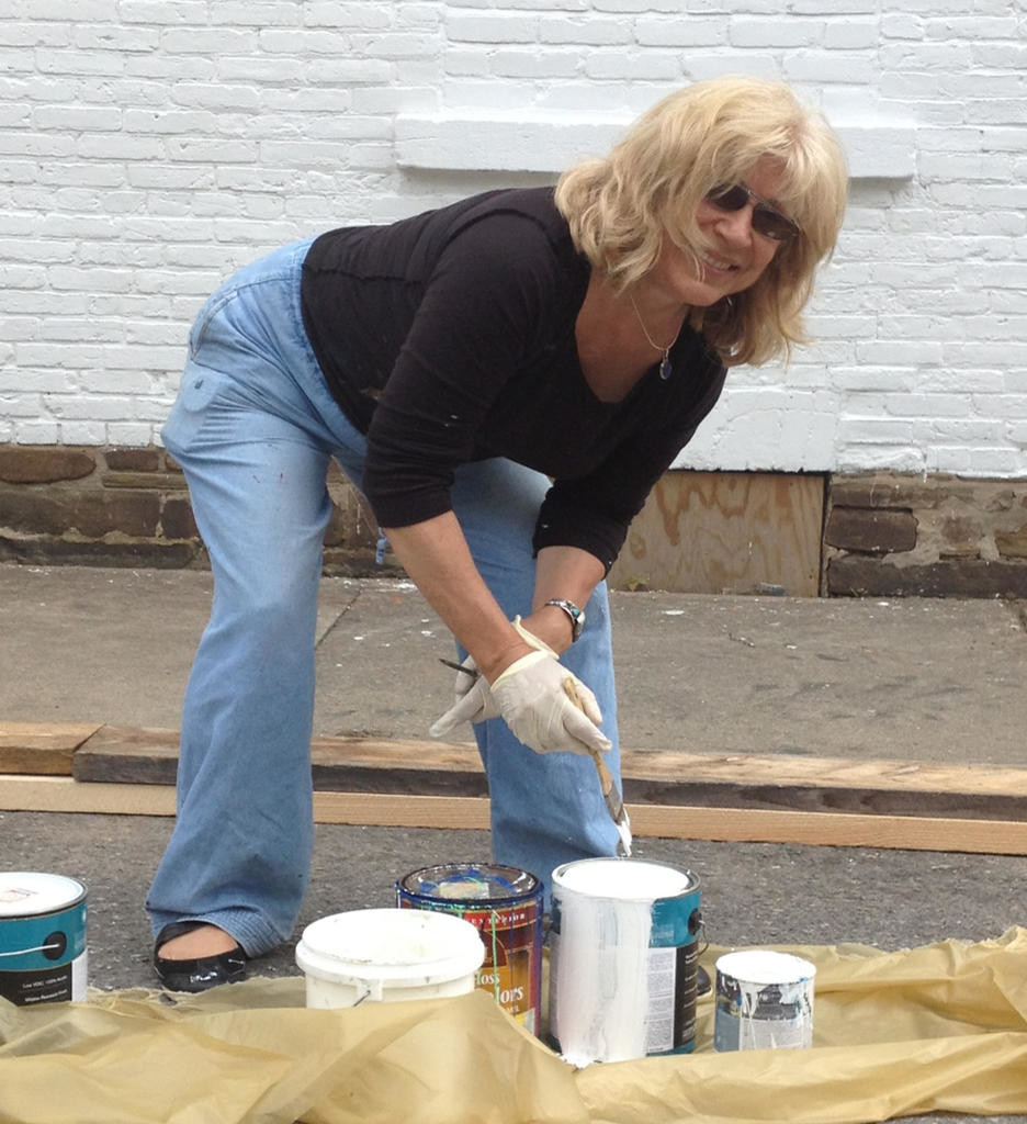 ARTIST IN ACTION — Artist and retired art teacher Jane Grace Taylor gets ready to paint the Camden Continentals mural on the VFW wall.  The mural is an enduring historic view of the renowned Camden group.
