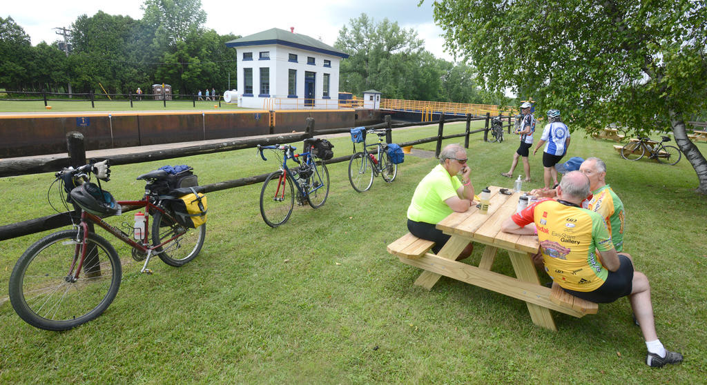 DOWN TIME — Bicyclists relax in the picnic area at Lock 21 in New London Thursday. Little breaks like this punctuate the 400-mile ride from Buffalo to Albany that started last Sunday and ends two days from now.