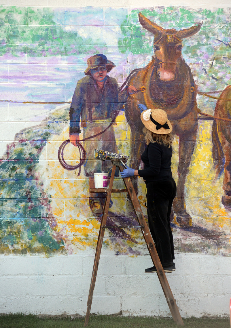 FINISHING TOUCHES — Rome artist Jane Taylor works on the details of a worker leading a team of mules in a scene from her Erie Canal mural in the Town of Verona.
 (Sentinel photo by John Clifford)