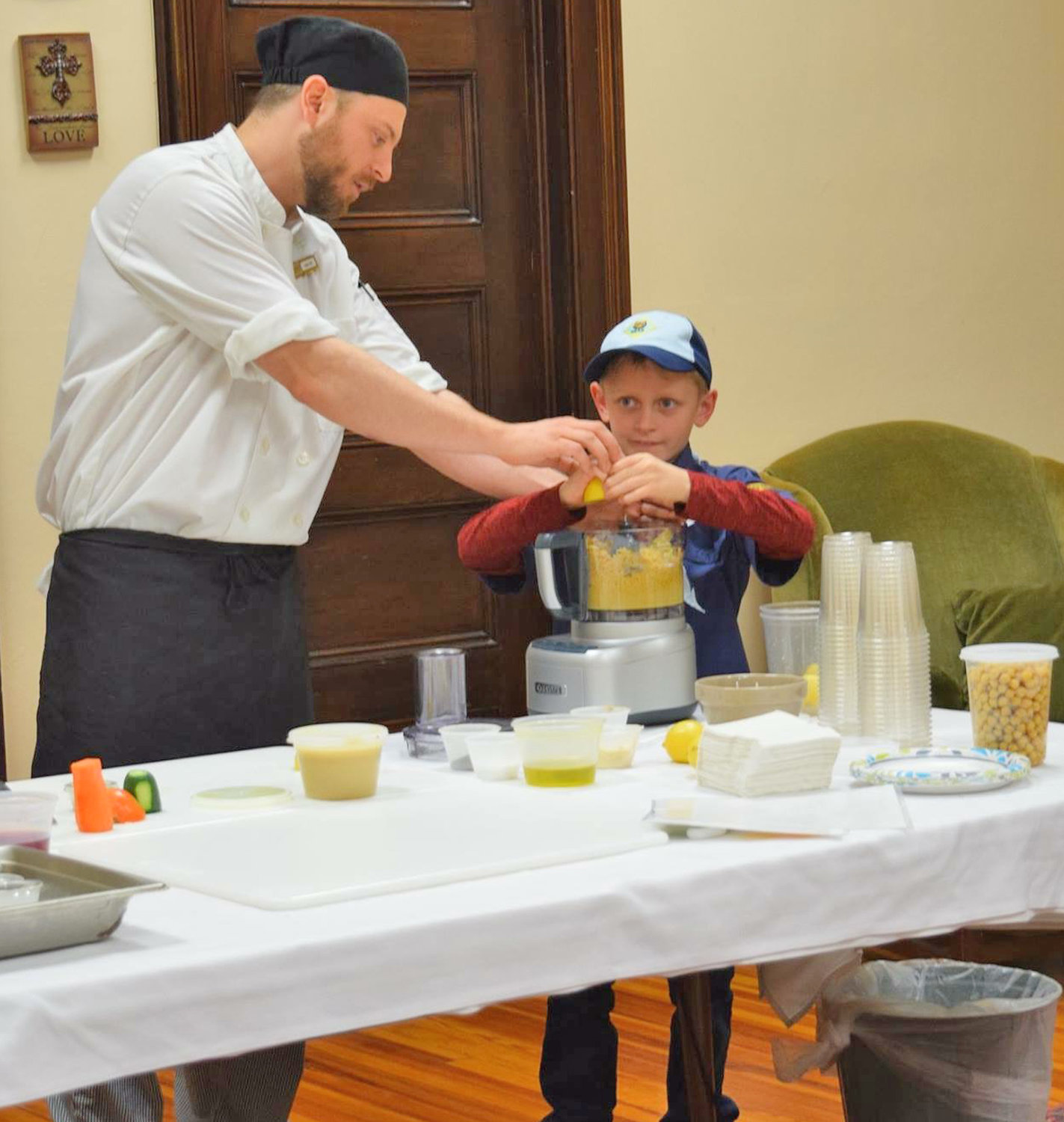 MIXING THINGS UP — Chef Steve Loson from Bon Appetit at Hamilton College and Bear Scout Brandon Tuttle prepare hummus in a food processor during a recent demonstration held in Rome about healthy eating.