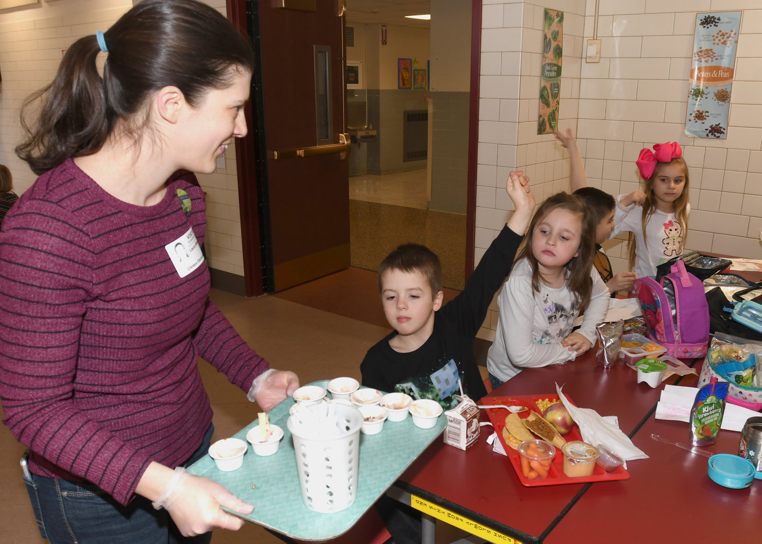 LET ME TRY — Parent volunteer Laura Wileczka hands out cups with the Farm to School “Harvest of the Month” program’s Asian Cabbage Slaw that was offered to children at Clinton Elementary School on Dec. 18.