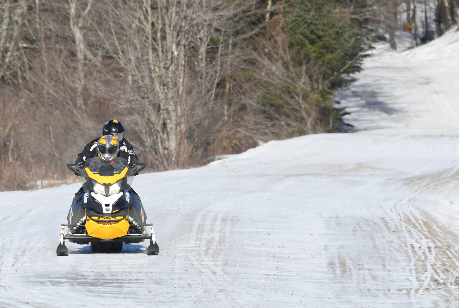 A lone snowmobile makes its way south on North St. in Old Forge on very a  thin icy trail. A lack of snow is hampering the winter past time in the north country.