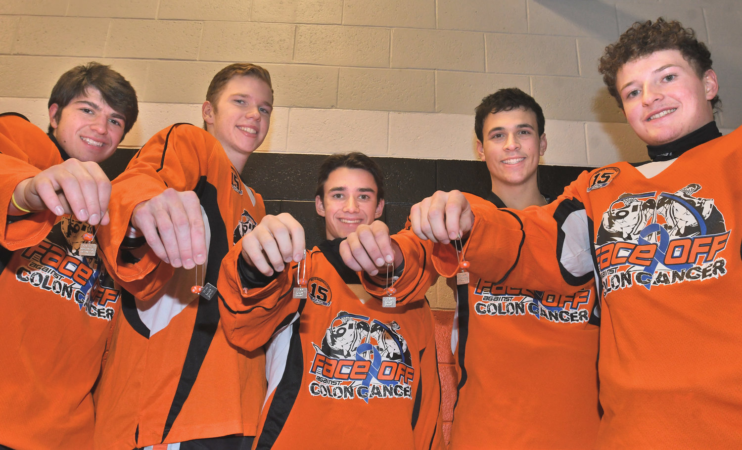 BEADS OF COURAGE — The Rome Free Academy ice hockey seniors hold up their Beads of Courage worn during Friday night's Face Off Against Colon Cancer benefit game at Kennedy Arena. From left: Michael Bostwick, Kyle Clark, Dylan Gannon, Danny Mecca and Aaron Simons. Pinned to their special orange jerseys, the beads are in honor of the Maureen's Hope Foundation. The players wrote messages of inspiration on them to children battling cancer. The beads are given to the foundation and distributed to children with cancer after treatment milestones. The recipients use them to make bracelets and necklaces that tell the story of their fight against cancer.