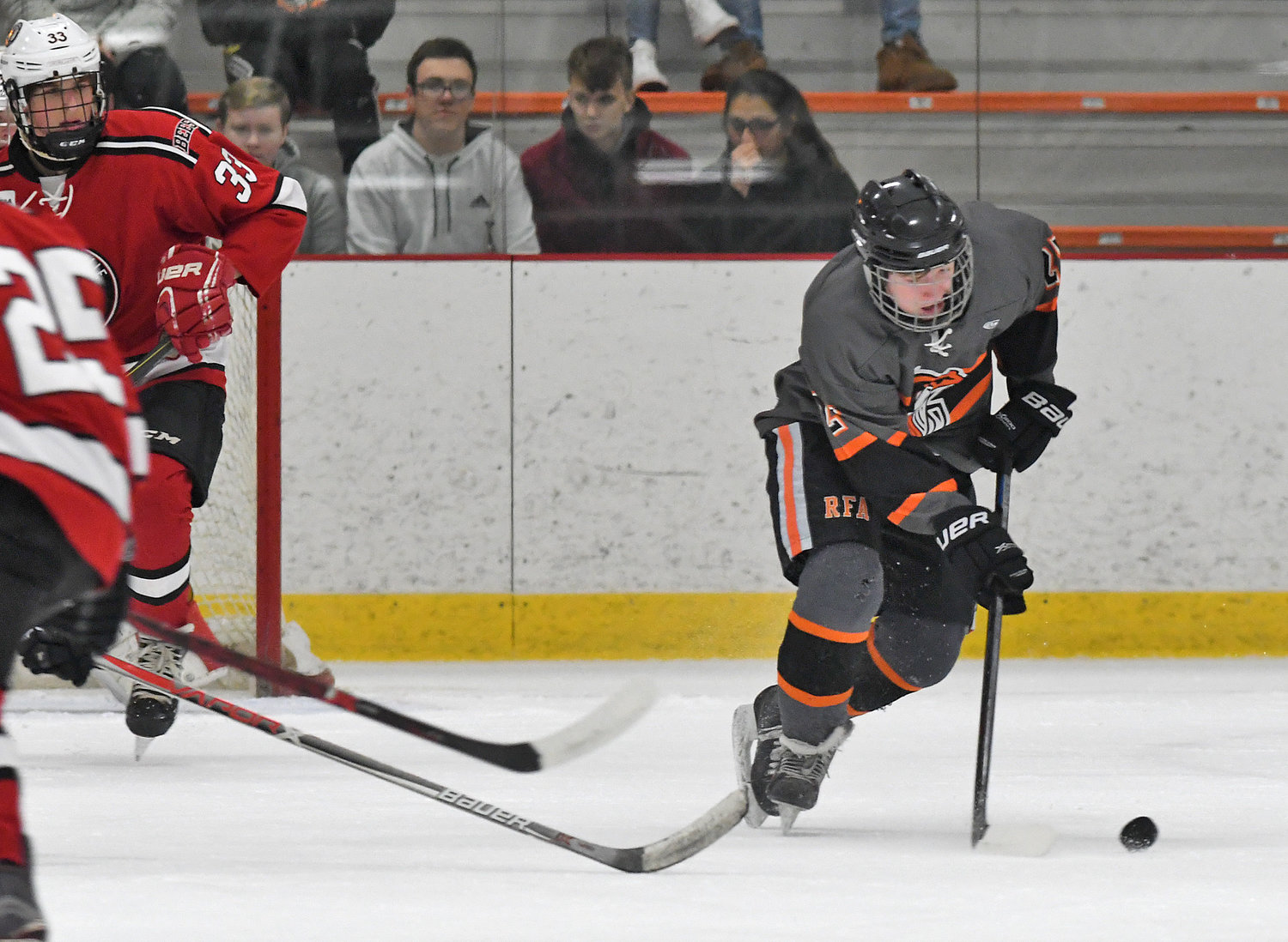 STRIKING FIRST — Rome Free Academy’s Eli Dormio grabs the puck in the Baldwinsville zone as defenseman Christian Treichler, 33,  closes in. Dormio wheeled around and scored the first RFA goal in Tuesday’s 4-1 win at Kennedy Arena.