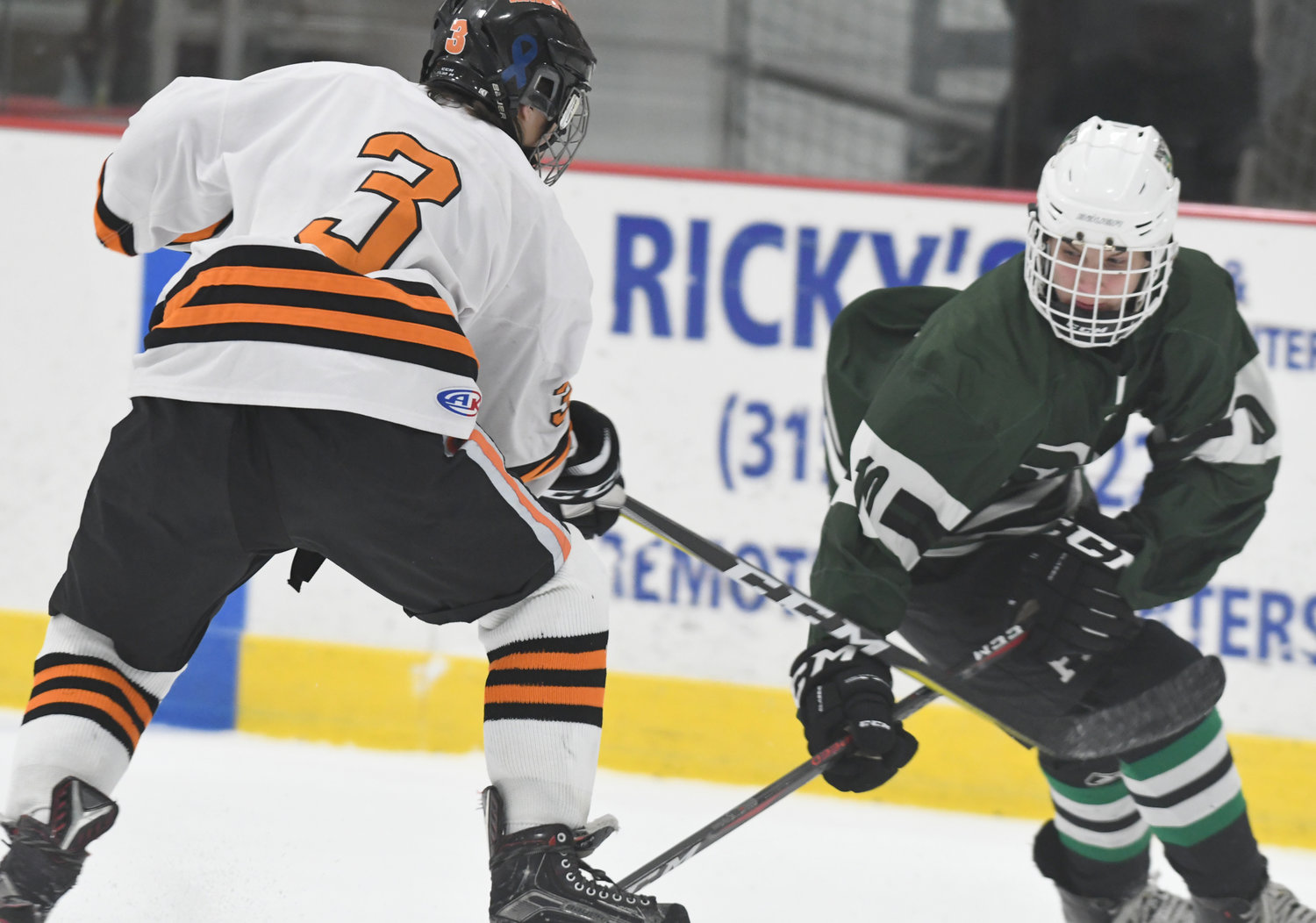 TRYING FOR A TURNOVER — RFA forward Kyle Lubey, left, tries to steal the puck away from Fayetteville-Manlius forward Josh Kuchinski during Tuesday’s game at Kennedy Arena. The visiting Hornets scored the first two goals and held off RFA for a 2-1 win.