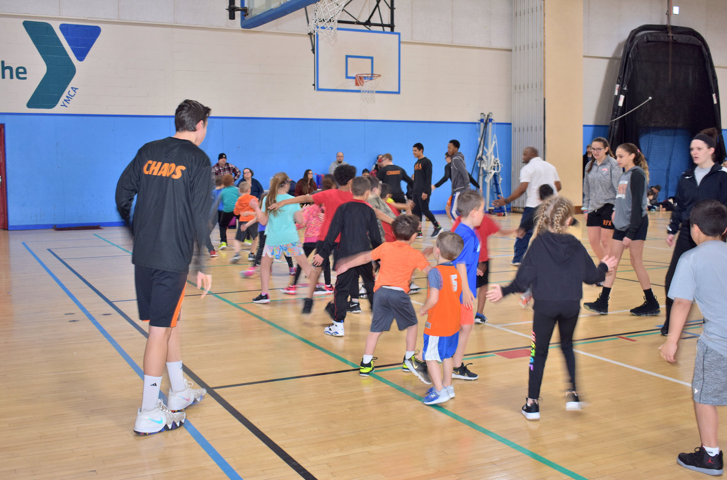 TEACHING AND LEARNING — Members of the Rome Free Academy boys and girls varsity  basketball teams help instruct youth in grades kindergarten through second during a recent learn to play basketball clinic session.
