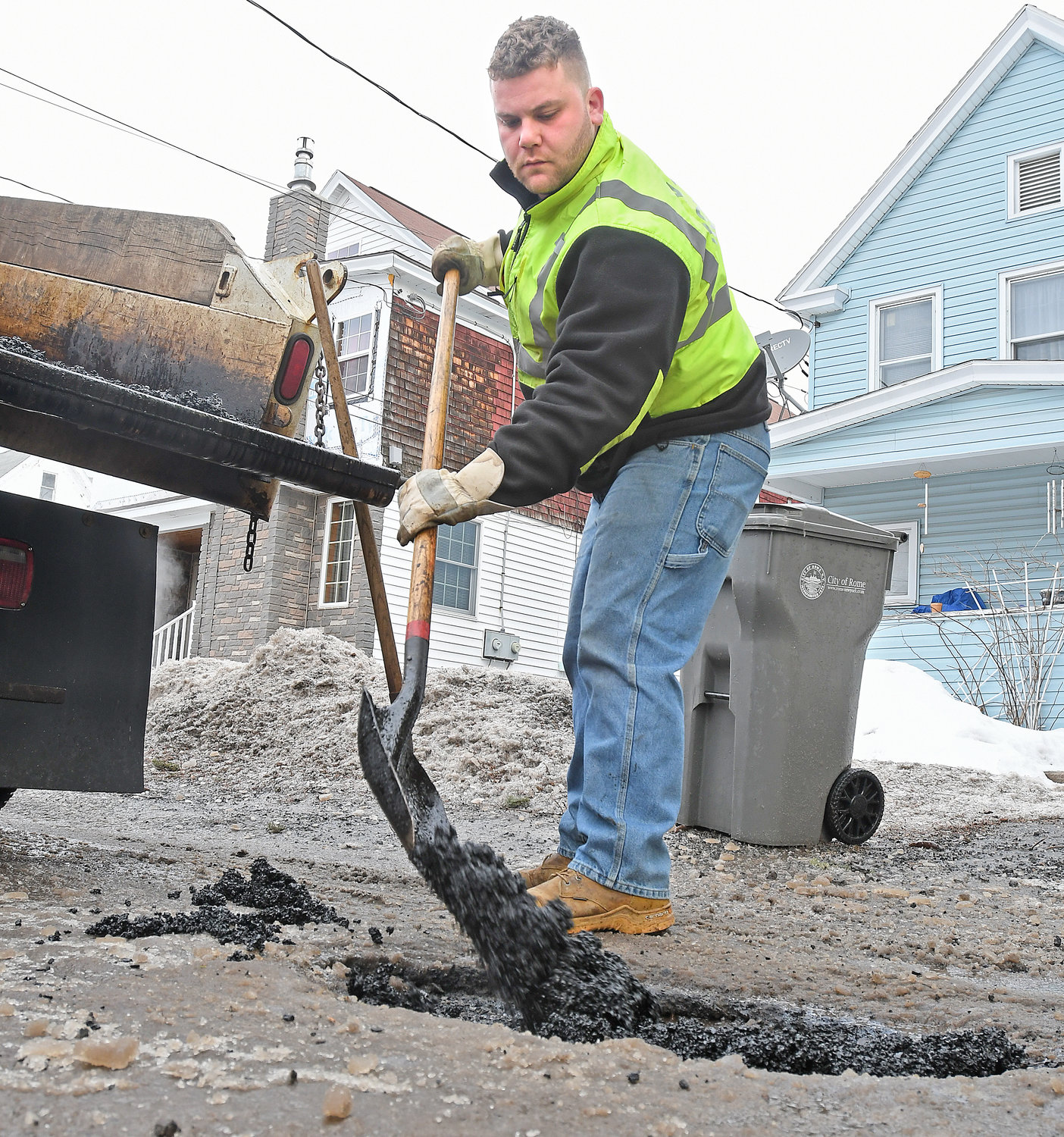 POTHOLE SEASON — DPW is taking advantage of the mild weather, as city worker Andrew DeBlasiis fills in a pothole on William Street with cold patch this morning. Residents can report potholes and other non-emergency issues to City Hall by downloading the RomeNY 311 app, available on iOS and Android devices, and following the onscreen instructions. This winter — with its fluctuating temperatures and mixed precipitation — has been ideal for  spawning potholes, which are often created when the precipitation leaks through cracks in streets and roadways and pools under the pavement and then expands as it freezes when temperatures drop.