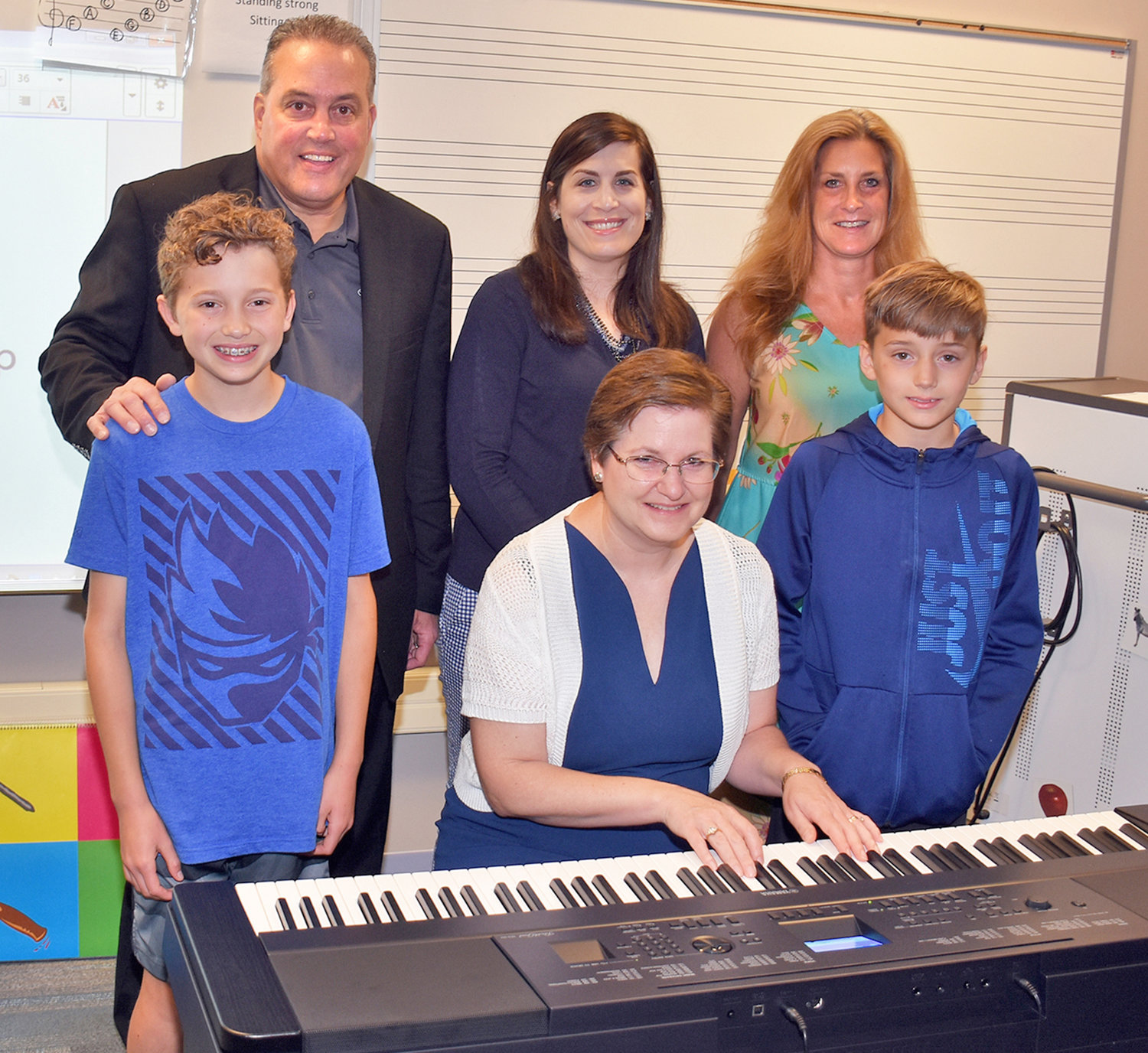 ELECTRIC PIANO DONATION — Shown with an electric piano that was donated to Joy Elementary School, in back at left: Rick Zuccaro, who made the donation and is an area musician and general manager at Carbone Subaru of Utica; school district Director of Fine Arts and Engineering Andrea Falvo; Joy school Principal Andrea Lacey. In front, from left: Joseph (Joey) Fiorini, sixth-grader; Joy school music teacher Diane Vicik; Anthony (AJ) Fiorini, fourth-grader. The Fiorinis are the grandsons of Dave Fiorini of the Carbone Auto Group, who also was instrumental in getting the piano donated.