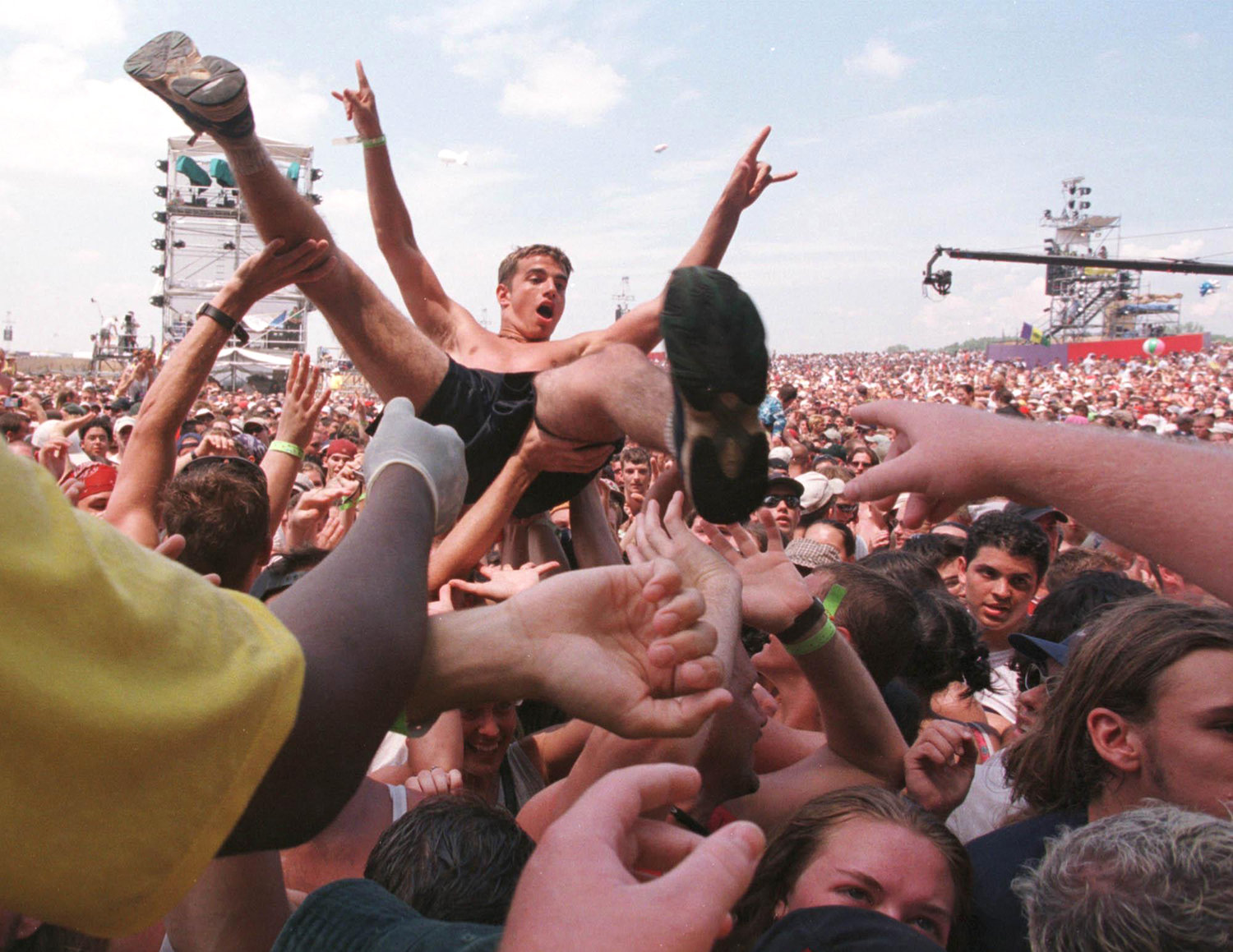 CROWD SURFING — A spectator crowd surfs in a mosh pit in front of the East Stage during the Woodstock 30th anniversary festival at the former Griffiss Air Force Base.