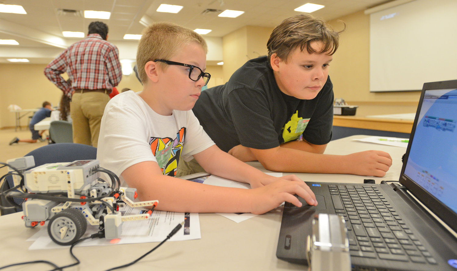 CHECKING THE PROGRAMMING — Denti Elementary School students Sam Colmey and Aidan Curry are at the keyboard to program their Lego robot for tasks to perform, during a STEM (science, technology, engineering, math) Outreach Program camp Wednesday at Griffiss Institute. The week-long Lego robotics camp, in conjunction with Rome Lab which is formally called the Air Force Research Laboratory Information Directorate, includes students in grades 5-8 who are learning how to build and program robots.