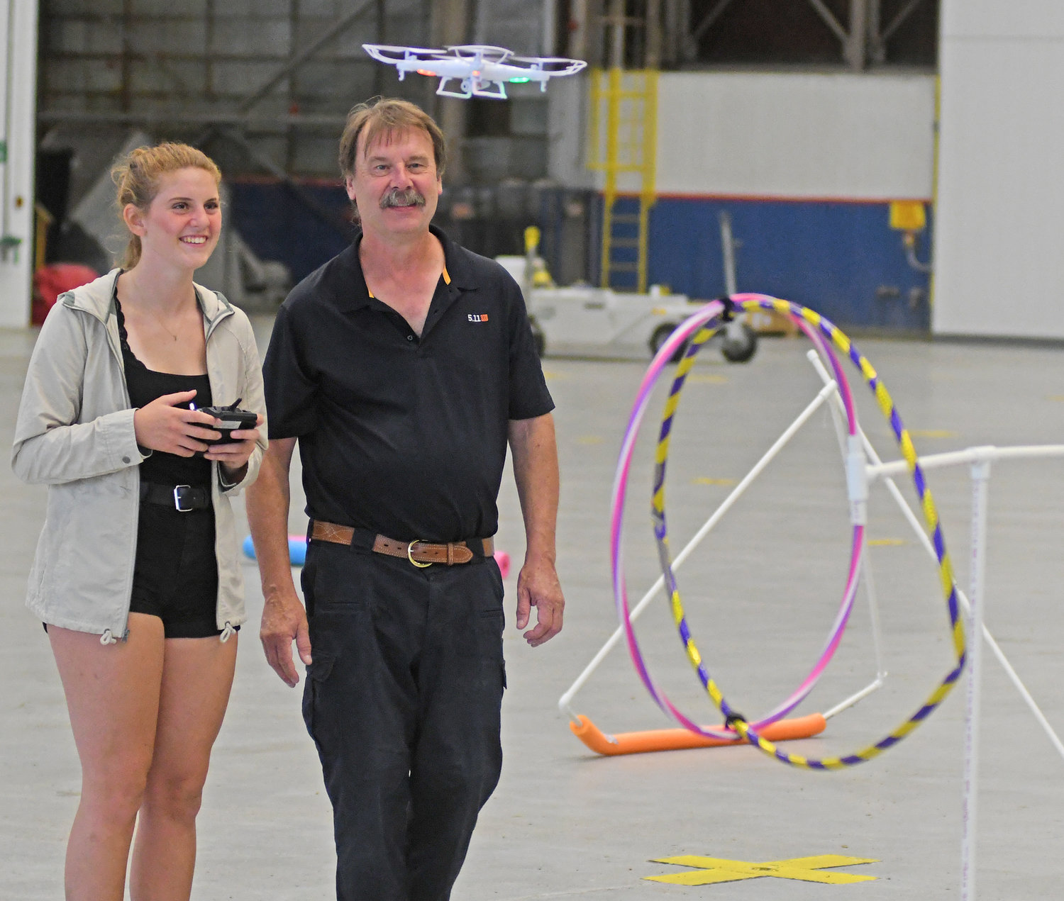 ON THE MOVE — Paige Novak, of Vernon-Verona-Sherrill High School, flies her drone through an obstacle course in Building 100 at Griffiss Business Park as instructor Bill Judycki looks on.