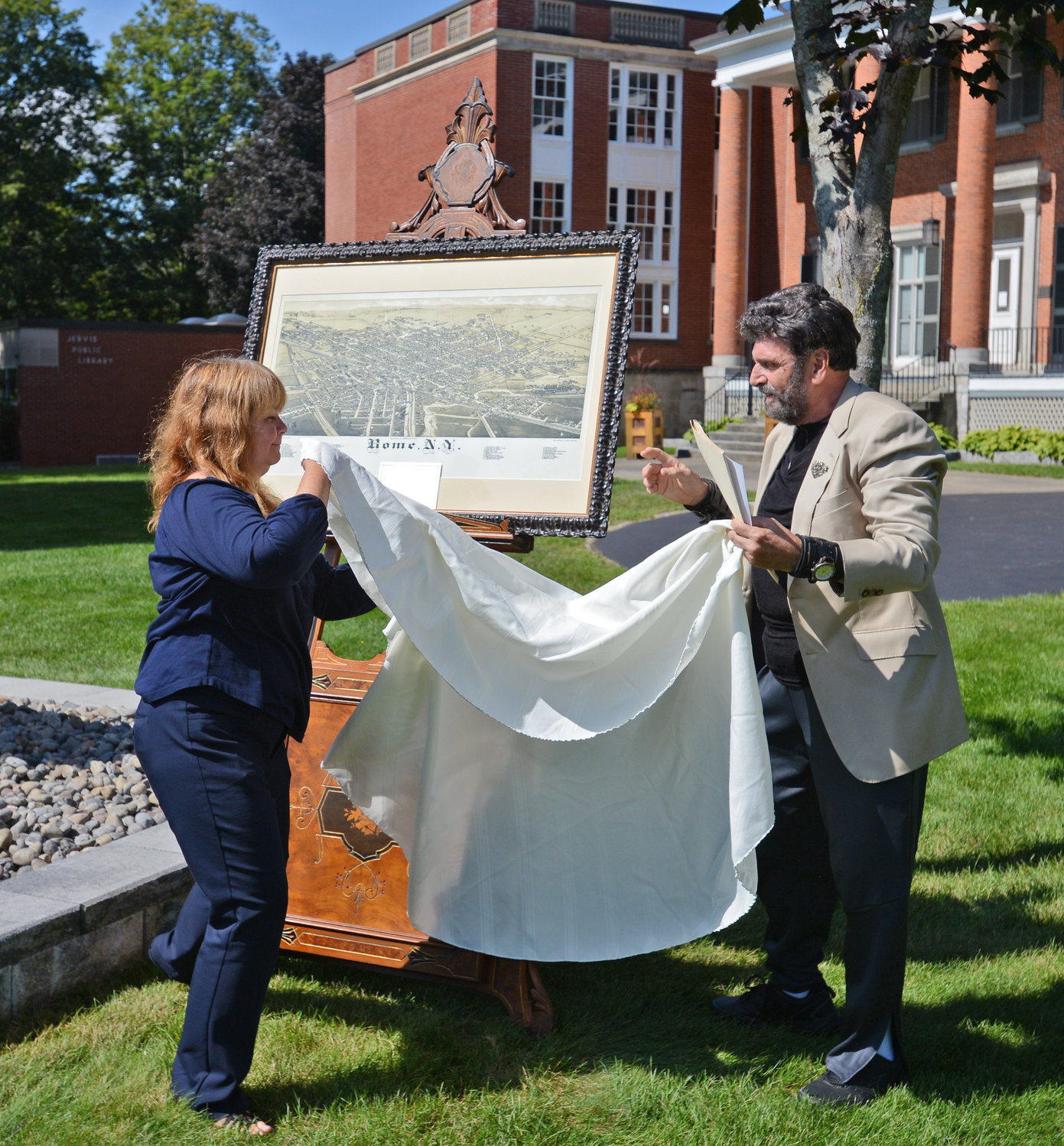 UNVEILING — Lori Chen and Steven Strange unveil the 1886 Lithograph map of Rome that was donated to Jervis Library and will be displayed in the Dillon Room.