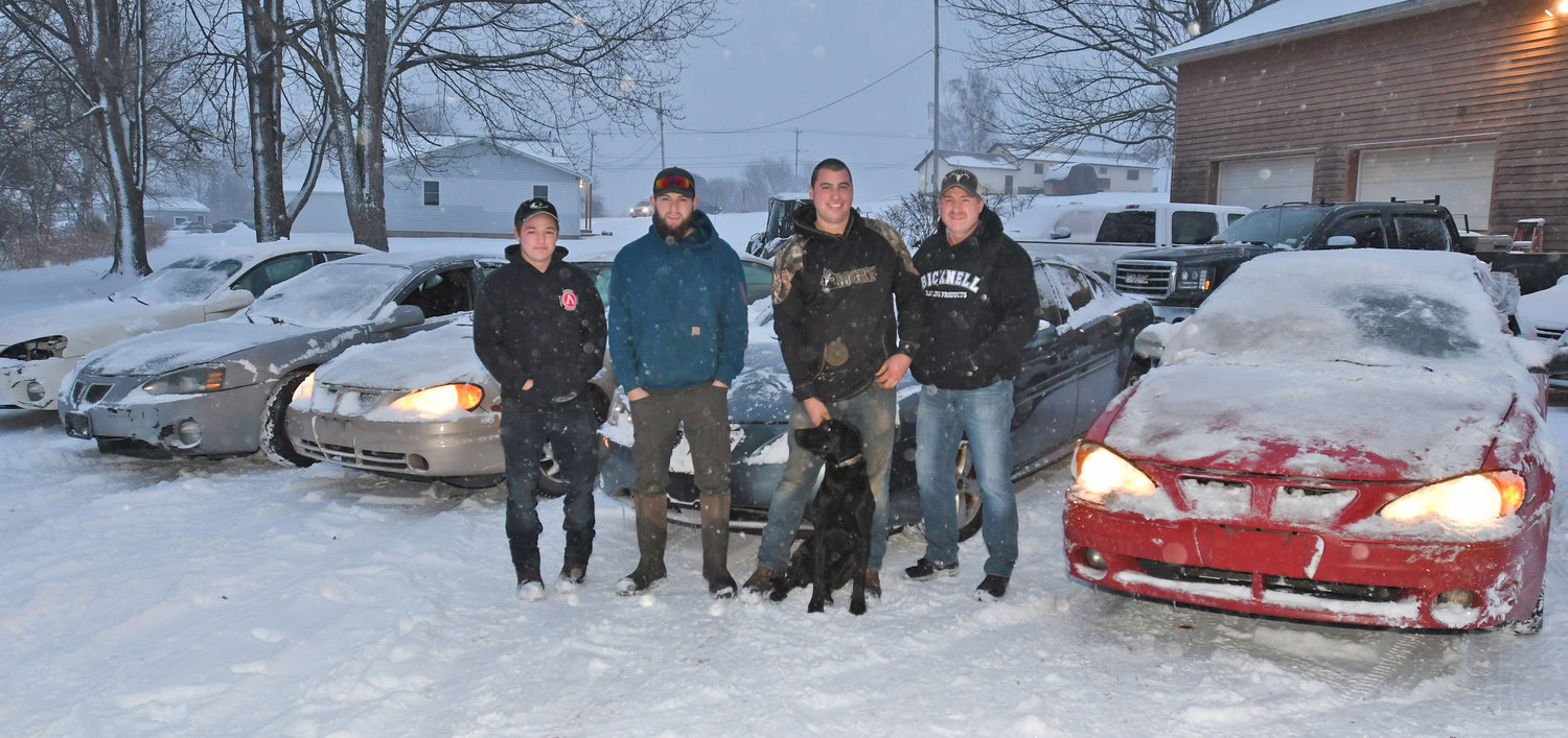 TEAM PONTIAC — Sixty drivers have signed up for the Hangover 2.0 on Jan. 1 at Utica-Rome Speedway. Four of those 60 are with the Pontiacs they will be driving (from left) Daniel “Tulip” Fancatt, Josh Knapp, Mike Richmond with his dog “Action” Jaxson and Mike Stiles. Stiles believes he will be the winner because as Richmond says the car he’s driving is actually road worthy.