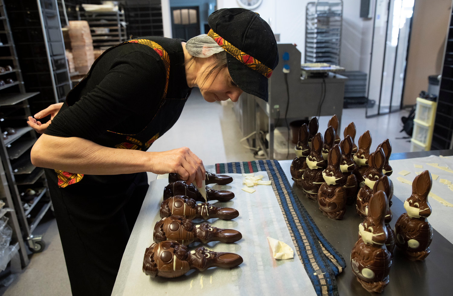 DECORATING — Genevieve Trepant decorates chocolate rabbits at her shop, Cocoatree, in Lonzee, Belgium.