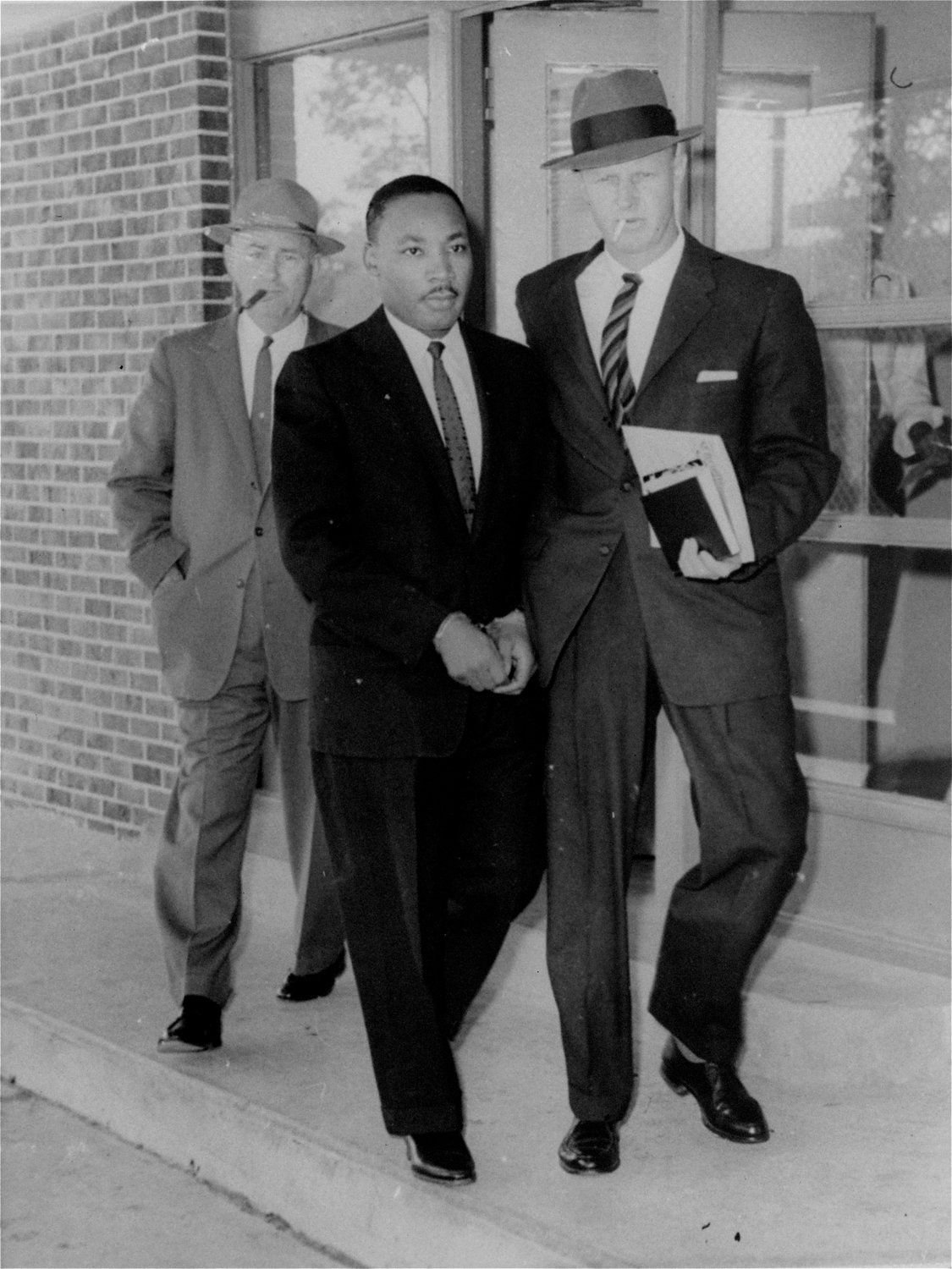 FILE - In this Oct. 25, 1960 file photo, Rev. Martin Luther King, Jr., integration leader, is escorted from the Atlanta, Ga. jail by two unidentified officers as he is taken to neighboring DeKalb county courthouse for a traffic hearing. Following the publication of "An Appeal for Human Rights" on March 9, 1960, students at Atlanta's historically black colleges waged a nonviolent campaign of boycotts and sit-ins protesting segregation at restaurants, theaters, parks and government buildings. (AP Photo/Horace Cort, File)