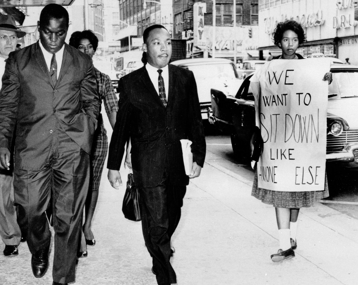 FILE - In this Oct. 19, 1960 file photo, Dr. Martin Luther King Jr. under arrest by Atlanta Police Captain R.E. Little, left rear, passes through a picket line outside Rich's Department Store, in atlanta. On King's right are Atlanta Student Movement leader Lonnie King and Spelman College student Marilyn Pryce. Holding the sign is Spelman student activist Ida Rose McCree. Following the publication of "An Appeal for Human Rights" on March 9, 1960, students at Atlanta's historically black colleges waged a nonviolent campaign of boycotts and sit-ins protesting segregation at restaurants, theaters, parks and government buildings. (AP Photo, File)