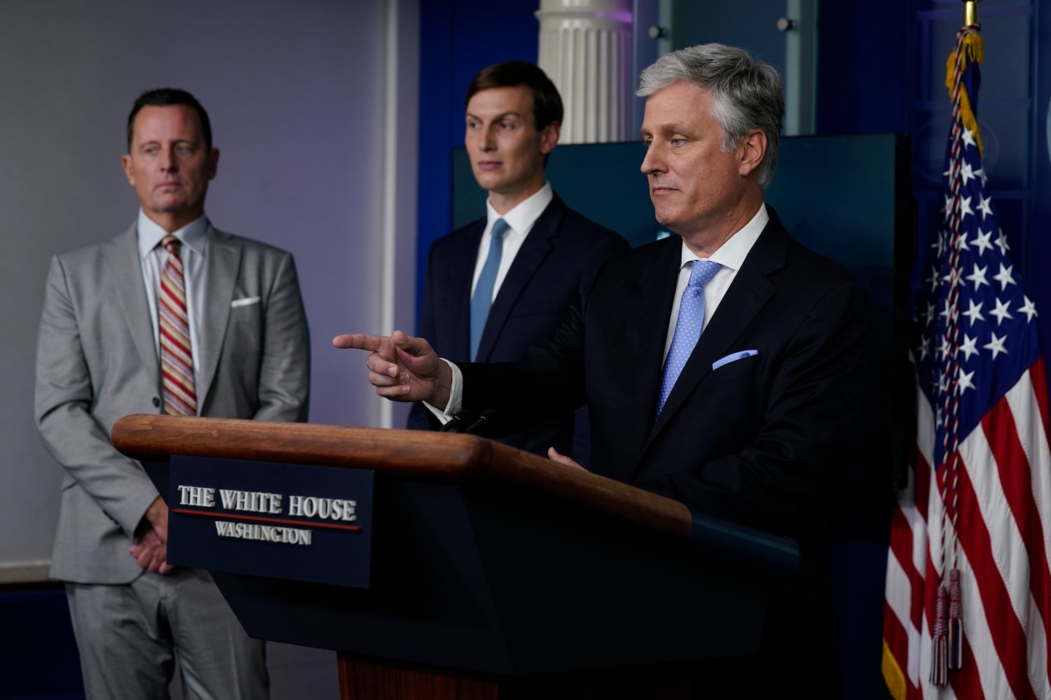 WHITE HOUSE BRIEFING — Adviser to the President on Serbia-Kosovo Richard Grenell, left, and Jared Kushner, center, listen as National security adviser Robert C. O’Brien speaks during a news conference at the White House Friday in Washington.
