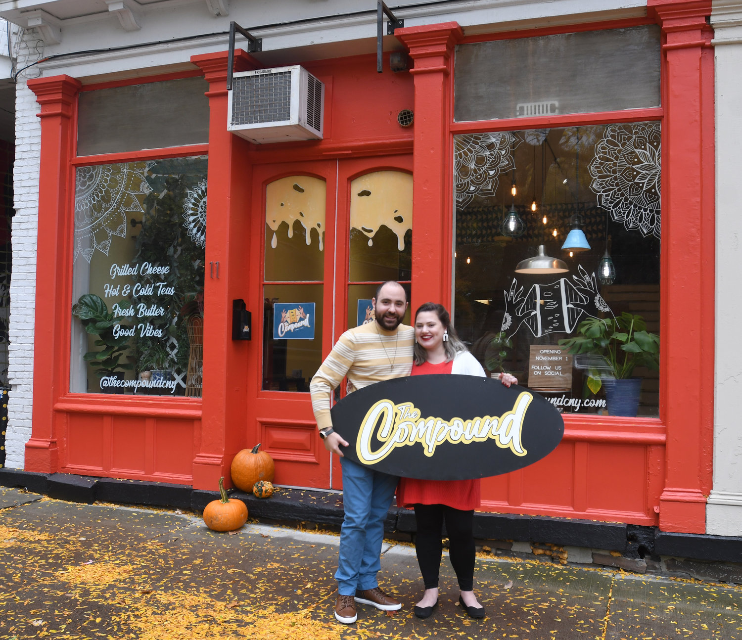 COMING SOON — Husband-and-wife team Sharrone and Anna Sofer stand in front of what will soon be their new cafe — The Compound — at 11 W. Park Row.  The Sofers plan to serve breakfast and lunch while featuring their homemade gourmet butters used to make their signature toasted cheese sandwiches.  The Compound will open on Nov. 1.