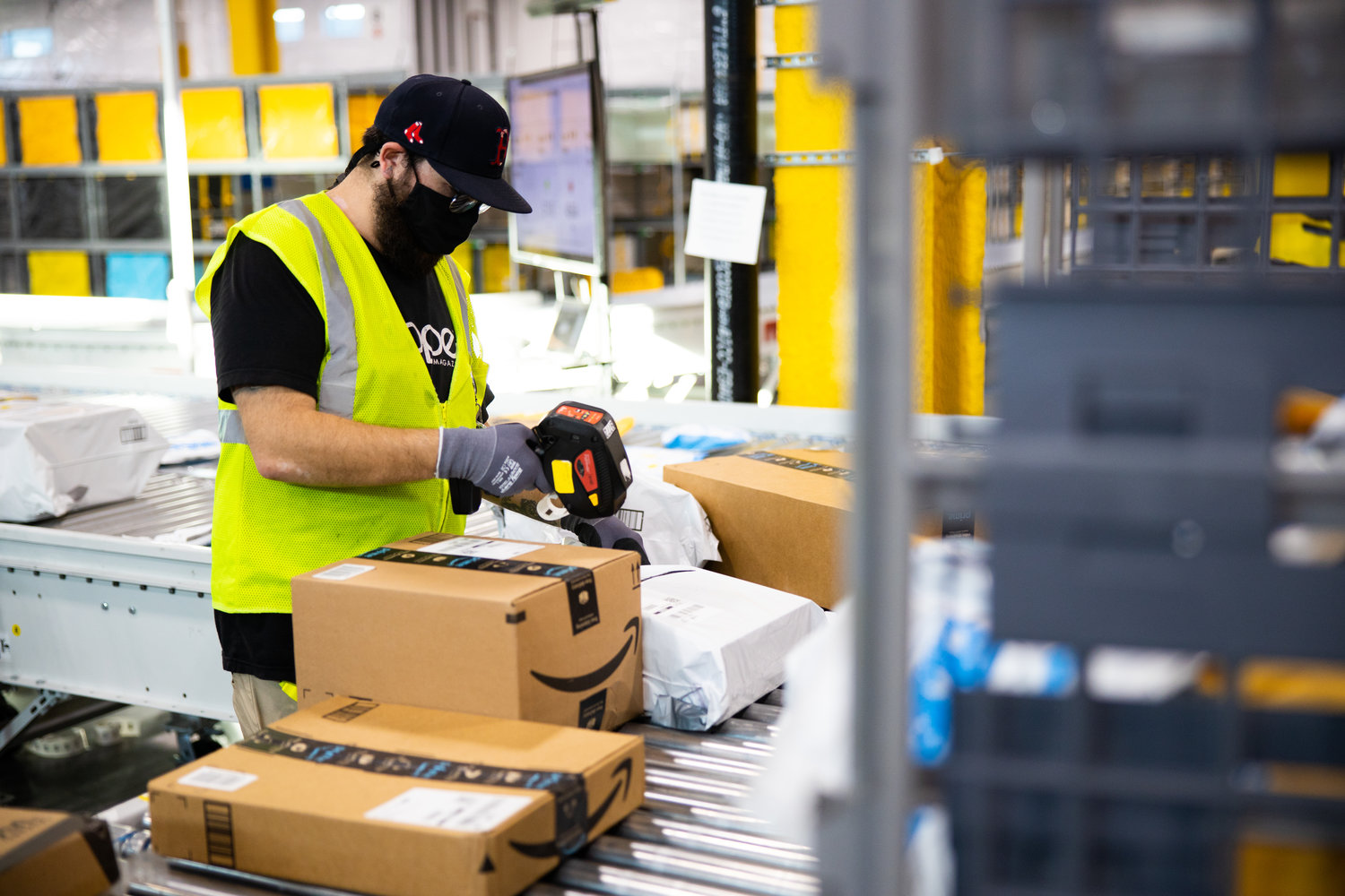 ON ITS WAY — An Amazon worker sorts a package in this company file photo. Amazon has announced a new delivery station currently under construction in East Syracuse will open for service early next year.