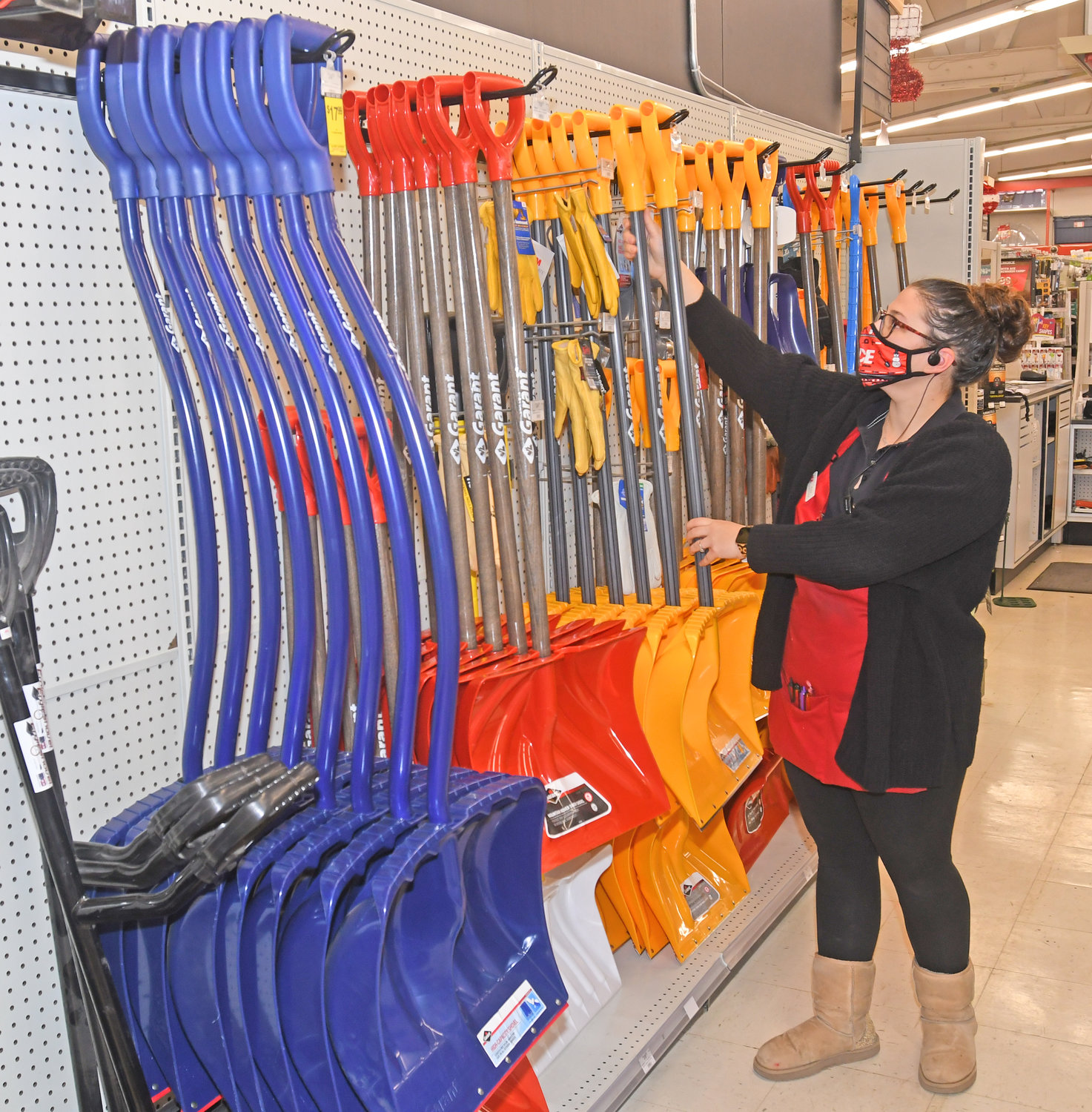 LOTS TO CHOOSE FROM — Alex Bauer, a supervisor at Ace Hardware for nearly 10 years, arranges one of the more than 15 different varieties of shovels available at ACE Hardware, 115 Black River Blvd.  Safety experts advise making sure you have the right shovel for the job and taking a variety of precautions to stay safe while clearing driveways, walkways and sidewalks.