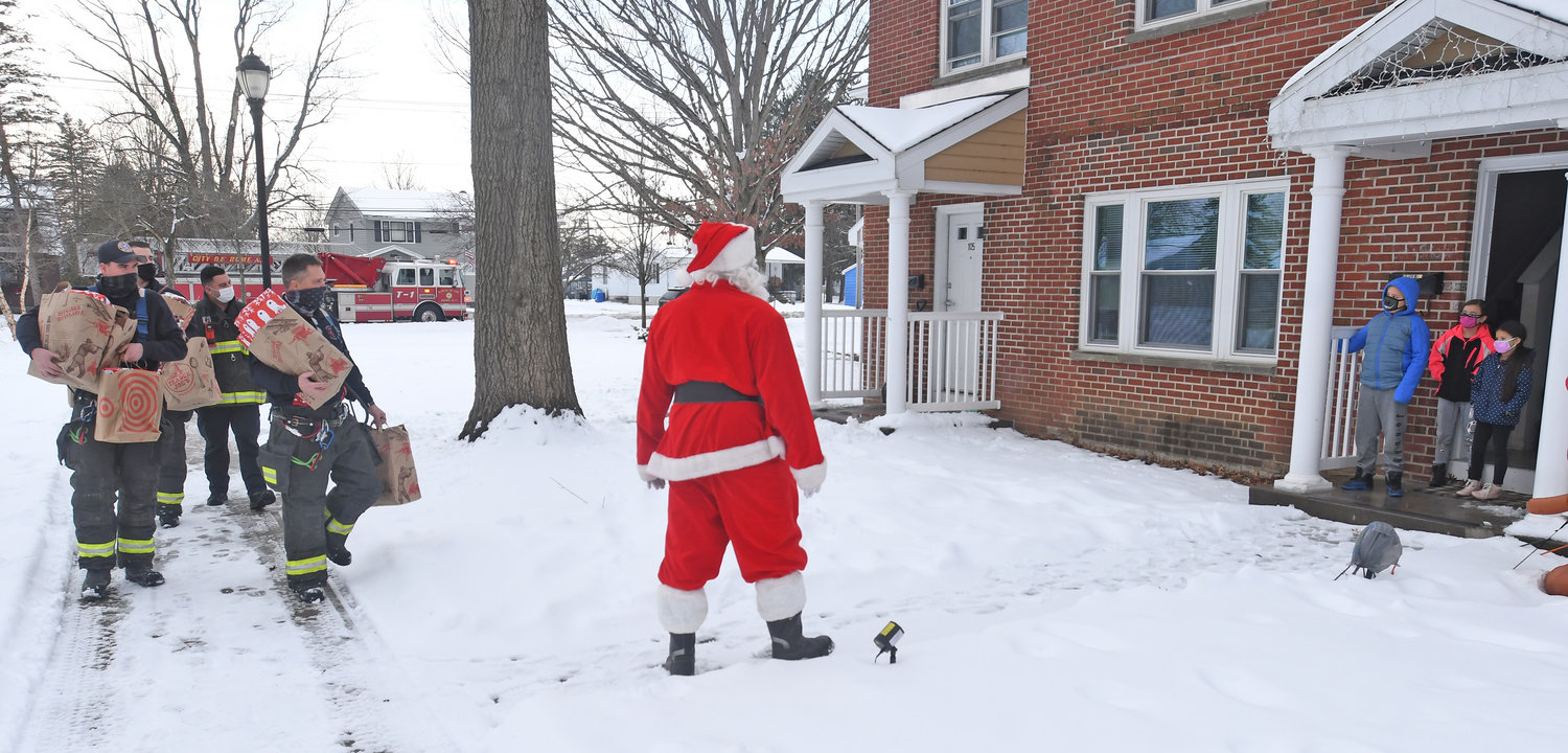 Rome firemen arrive at Liberty Gardens apartments to hand out gifts to children Monday afternoon.