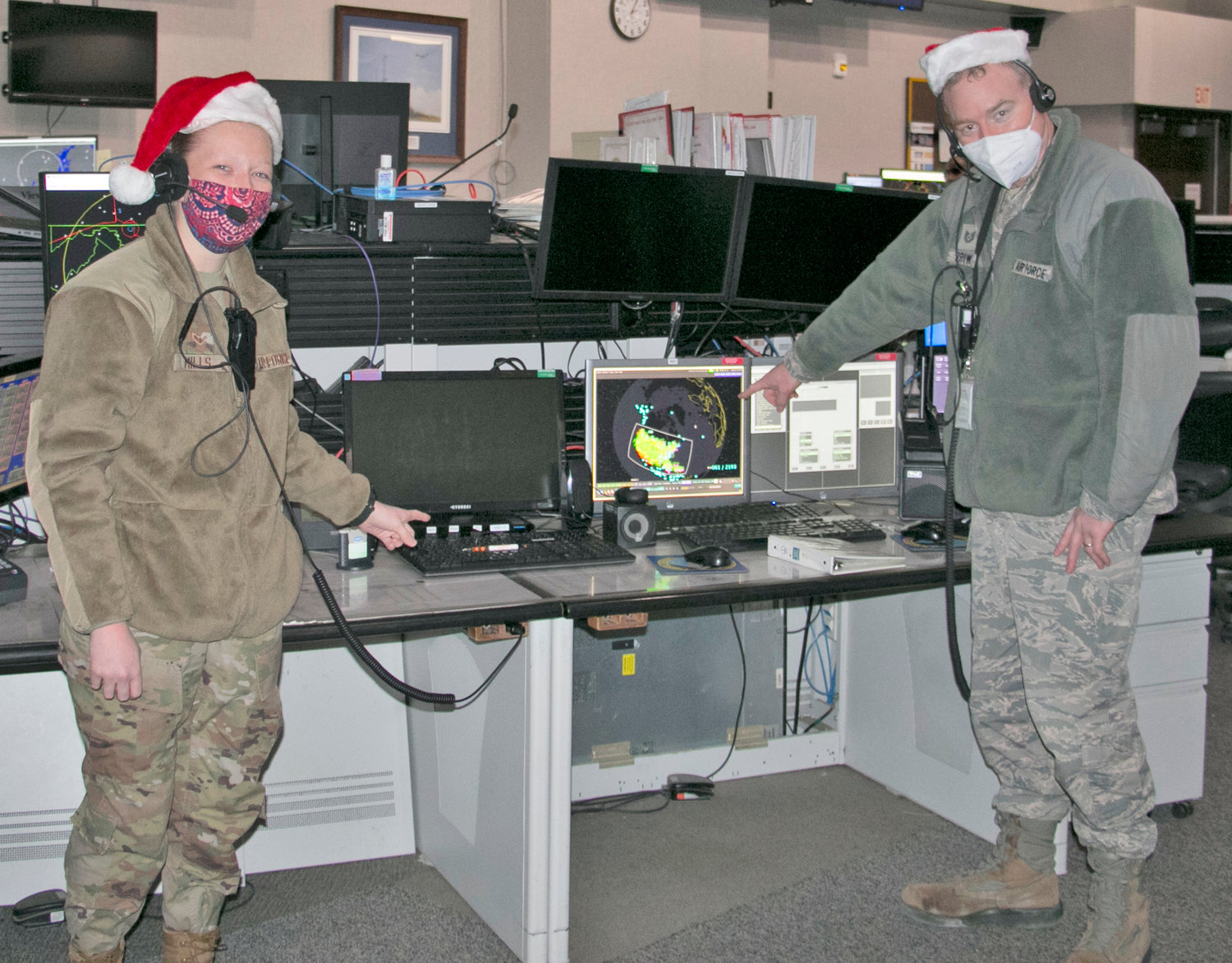 PREPARING TO MONITOR SANTA — Airman 1st Class Megan Mills, left, and Tech. Sgt. Kriston Brown participate in a recent Santa Claus tracking exercise at the Eastern Air Defense Sector. They were prepping for today, Christmas Eve, when EADS will support the North American Aerospace Defense Command’s (NORAD) annual Santa tracking efforts.