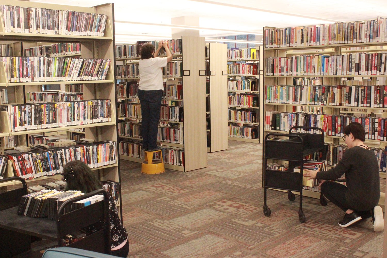 NEW LIBRARY — Staff restock the shelves at the Oneida Public Library’s new facility in Oneida on Elizabeth Street. The Library is expected to start doing business with the public by mid January.