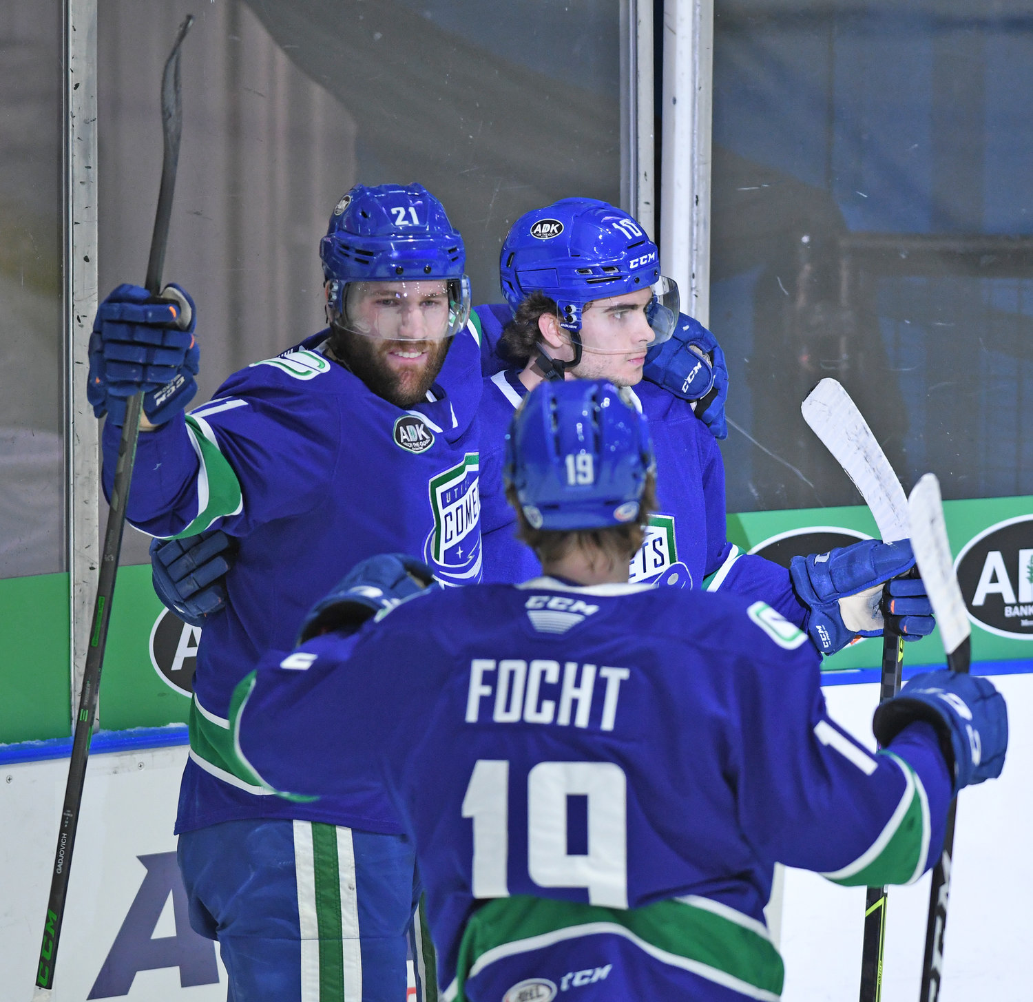 FIRST BLOOD — Jonah Gadjovich of the Utica Comets (21), celebrates with teammates Carson Focht (19) and Will Lockwood after he got the opening goal in Wednesday’s home opener against the Syracuse Crunch at the Utica Aud. Gadjovich added an empty net goal to seal a 5-2 win.