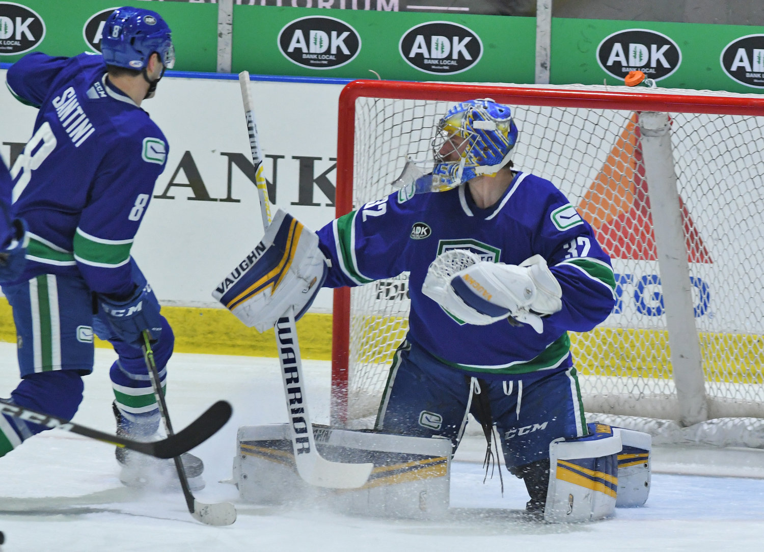 BACKSTOPPING TO A WIN — Utica Comets goalie Jon Gillies reacts to a shot as defenseman Steve Santini helps protect the net in Wednesday’s home opener against the Syracuse Crunch. Gillies stopped 17 shots to earn the win for the Comets in net.