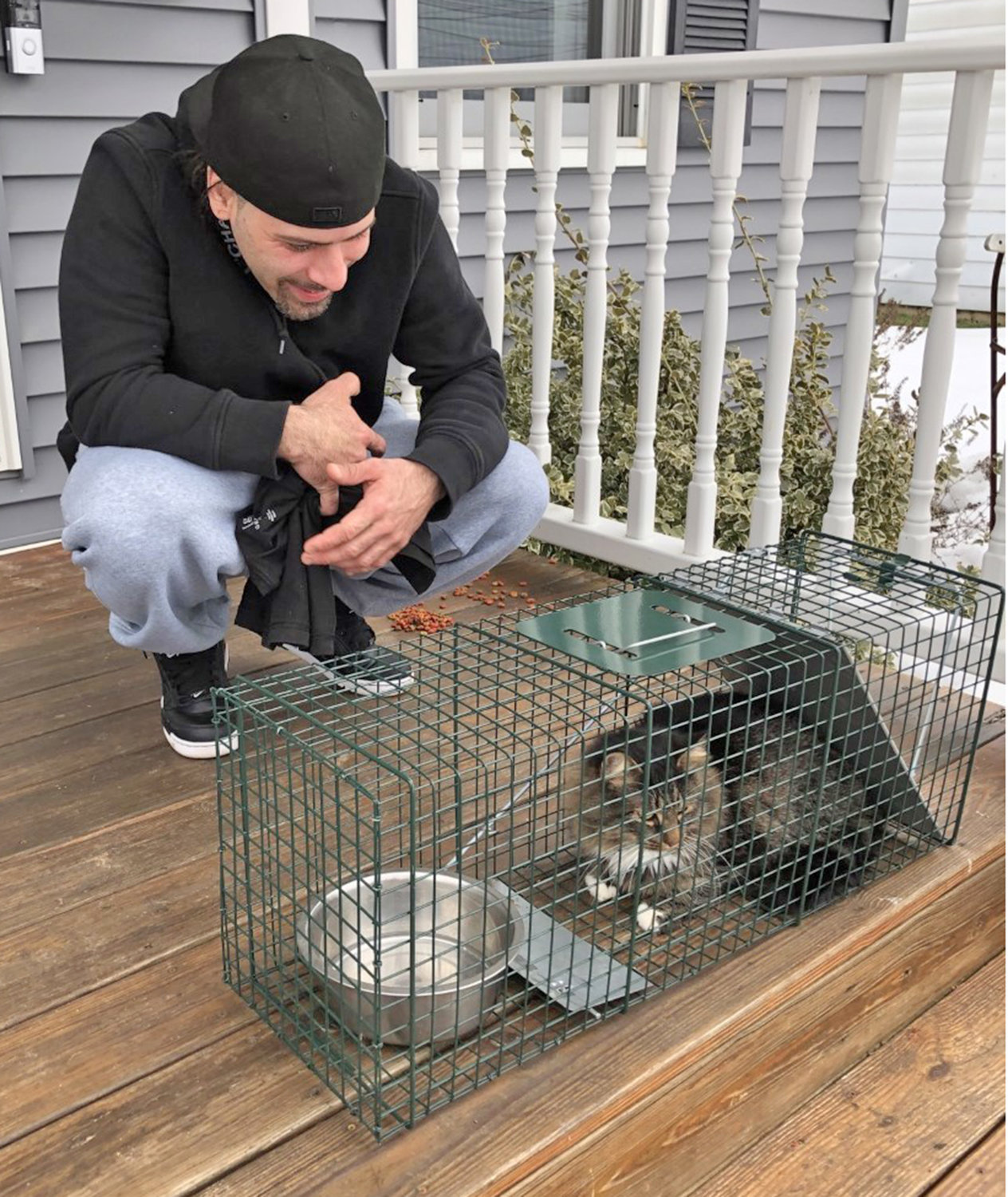 BUDDIES REUNITED — Benji Pedroza, of Court Street, says, "Hello," to feline friend Buddy shortly after being rescued on Feb. 28.  Buddy somehow escaped from Pedroza's house and had been missing for at least two months.