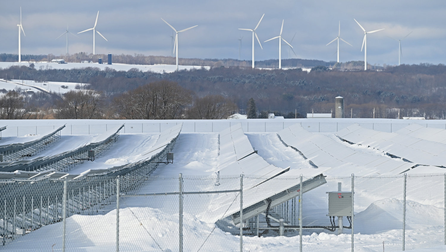 Snow covered — Solar panels sit in a field of snow off Flat Rock Road just south of Lowville with Martinsburg windmills in the distance Friday morning.