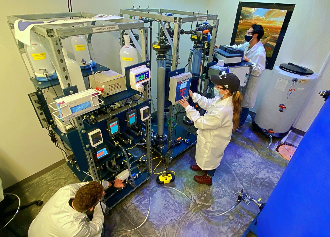 SMALL SCALE WATER TREATMENT — University of Rhode Island engineering students Steve Lucier, left, Pam Franco and, C.J. Spellman execute an evaluation of ferrate using URI’s pilot-scale water treatment system. The system is a 1:10,000 scale of a typical water treatment plant.