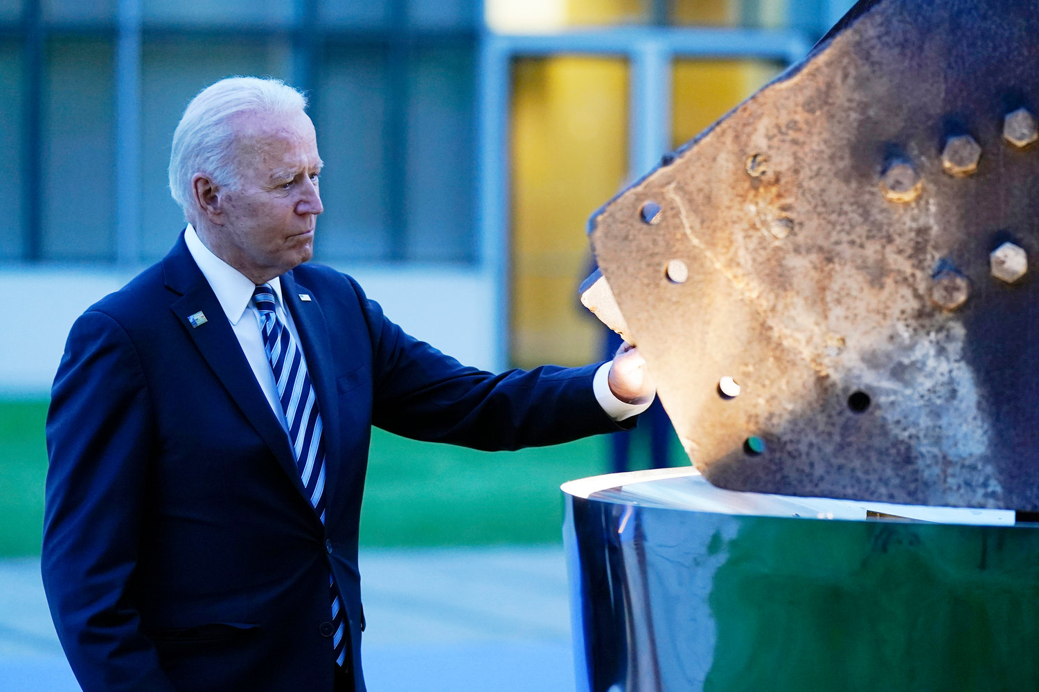 MEMORIES — President Joe Biden touches a piece of steel from the North Tower of the World Trade Center while visiting a memorial to the September 11 terrorist attacks at NATO headquarters in Brussels Monday.