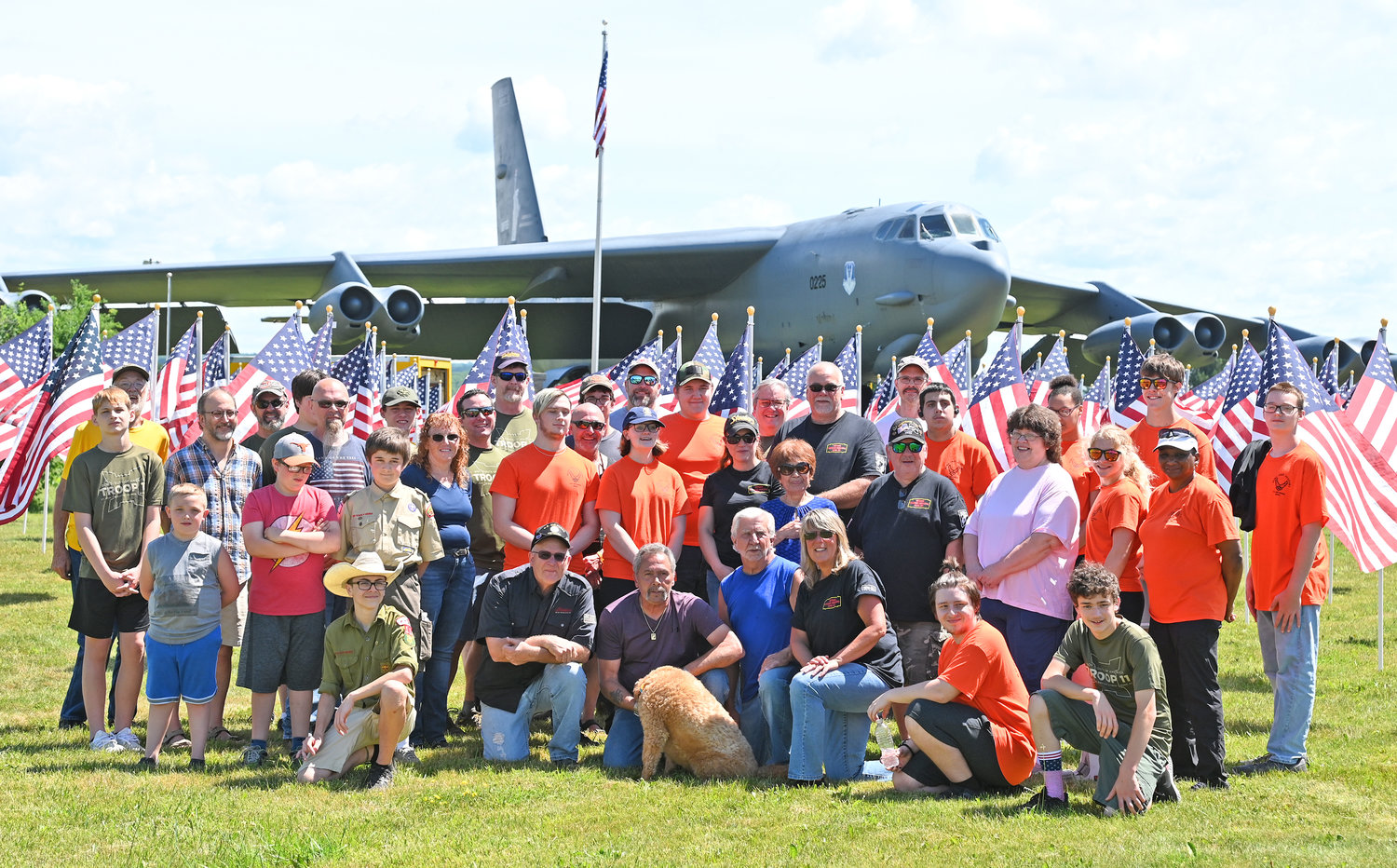 TEAM PHOTO — Volunteers responsible for putting out the more than 500 American flags that comprise the Flags of Honor display in front of the B-52 bomber pose for a group photo after their efforts in the heat and sunshine.