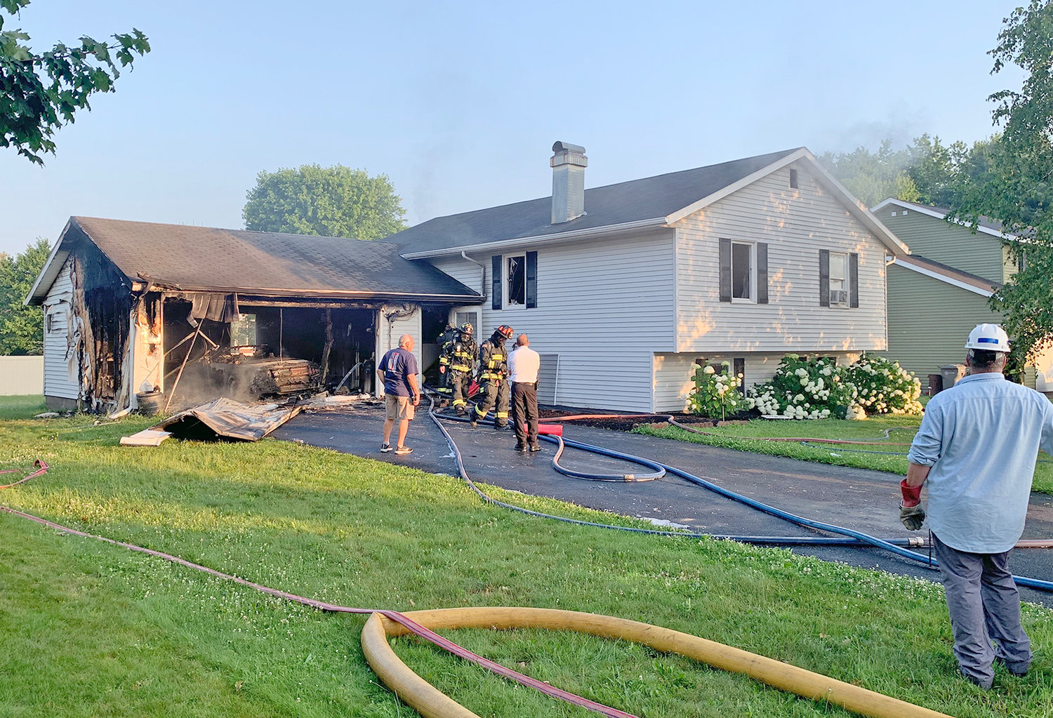 GARAGE IS LOST — Rome firefighters work on the mess left behind following a garage fire on Winfield Circle in north Rome early Tuesday morning. Fire officials said no one was injured; the residence sustained smoke and water damage.