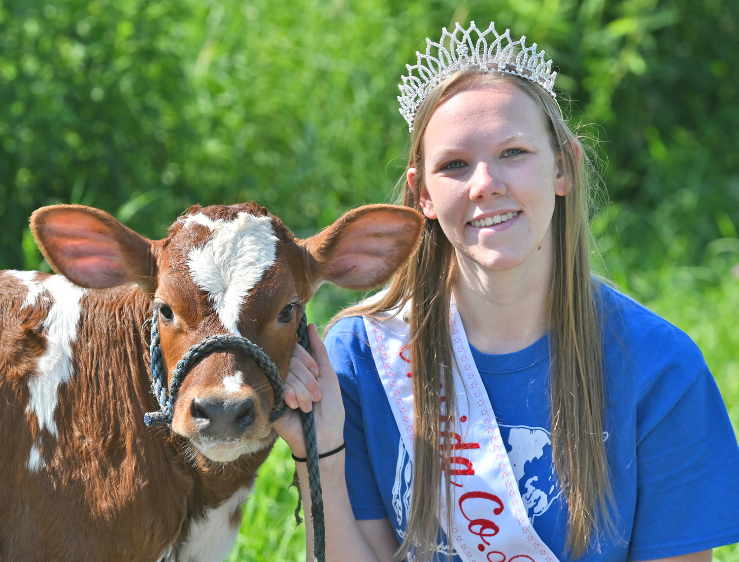 SAY CHEESE? — Oneida County Dairy Princess Shelby Carrigan takes a brief break from her chores to pose for a photo with Melinda, an Ayrshire calf. Carrigan’s chores on the farm include feeding and caring for calves like Melinda.
