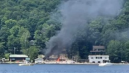 LAKESIDE HOME EXPLODES — Debris lies strewn about and black smoke fills the air after a residence on First Lake in Herkimer County exploded Friday afternoon. One person near the residence suffered a minor injury, authorities said. The cause of the explosion remains under investigation.