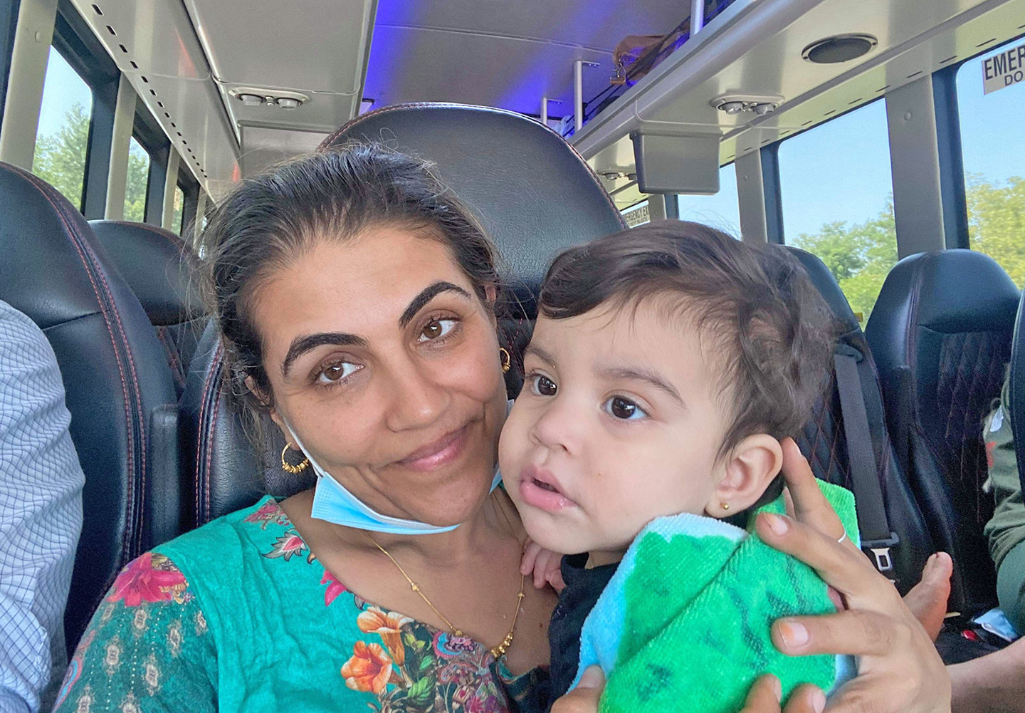 GOING HOME — Faziya Nematy, of Schenectady, holds one of her children during their Hale Transportation bus ride back home Thursday after escaping from Afghanistan with the help of two New Hartford Volunteer Firefighters Sean D. Mahoney and John Jensen.