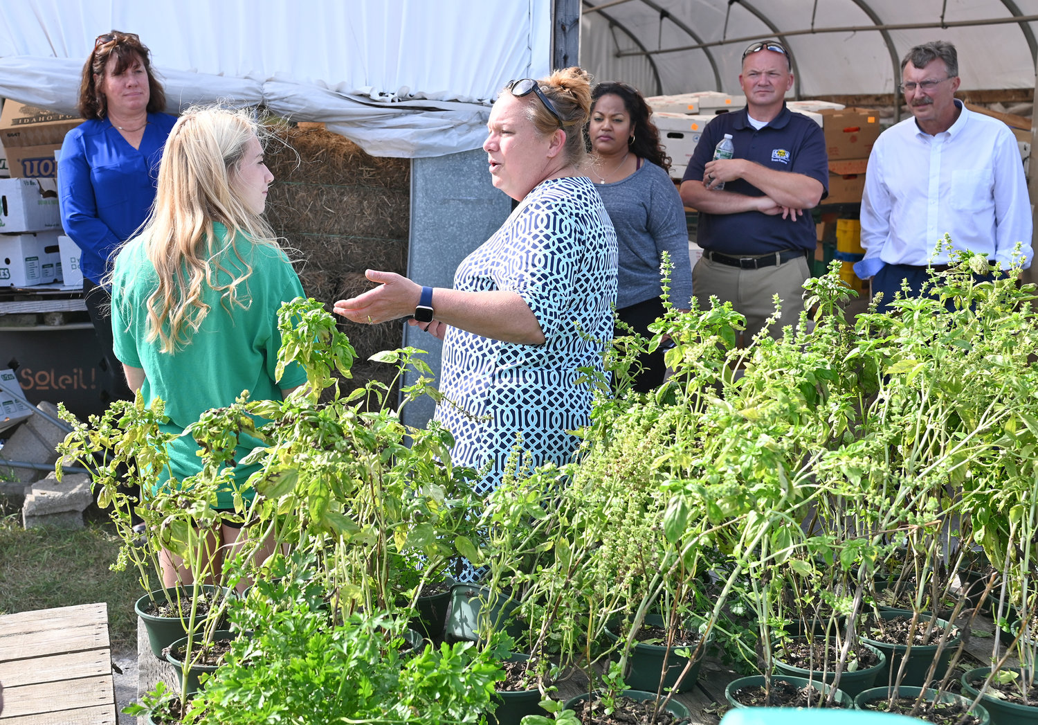 FARM TALK — Shawna Candella Papale and her daughter, Sara, talk with the group of state Assembly members, including Marianne Buttenschon, D-119, Marcy, about their farm and business, Candella’s Farm and Greenhouses, 9256 River Road in Marcy, on Tuesday. Buttenschon hosted a tour of six local farms in the Mohawk Valley for several fellow Assembly members, including Aileen Gunther, D. Billy Jones, Jen Lunsford, Jaime Williams, Catalina Cruz, Agricultural Committee Chairperson Donna Lupardo, and Brian Miller, R-101, New Hartford, for visiting some of the great farmers and business leaders in the 119th District,’’ Buttenschon said, and to help educate and inform them on issues facing the agricultural industry in her district and across New York. In addition to Candella’s, the tour also made stops at R. Jones Nursery and Landscaping Center in Rome; DiNitto Farms, Sciortino Farms and Buttenschon Tree Farm in Marcy; and the Collins Farm Creamery in Rome.