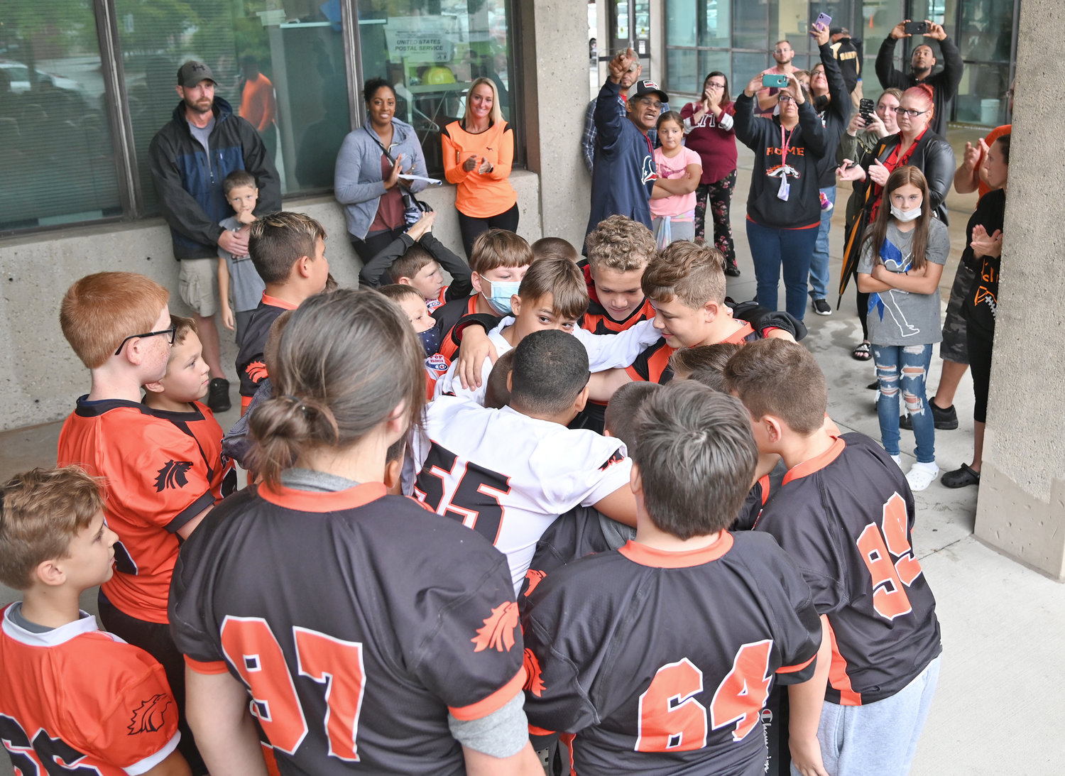FOOTBALL ON HOLD — Members of the Rome Colts 12U football team huddle up outside City Hall Thursday in hopes that someone would listen to their pleas to be allowed to play again. As a result of the fight, tackle football has been suspended in Rome for the rest of the season, according to Tri-Valley Pop Warner officials.
