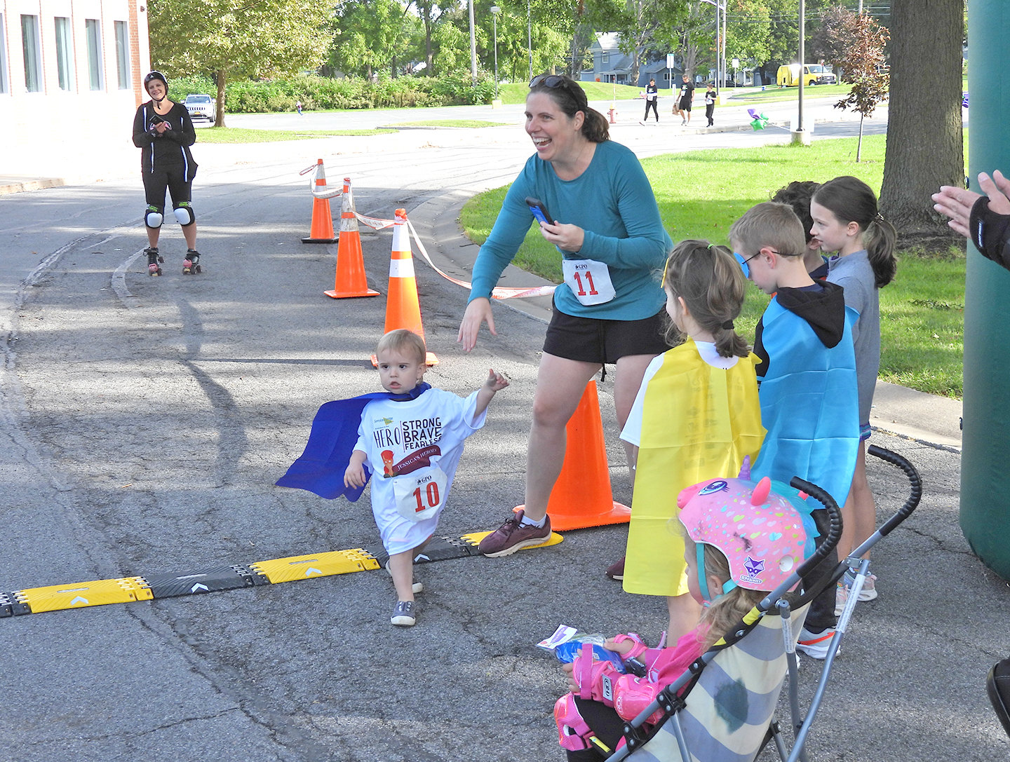 YOUNG AND RUNNING — A young child makes it across the finish line at Jessica’s Heroes 5K Walk and Run. Besides raising money, Jessica’s Heroes helps unite people and show local cancer victims that the community is there to support them.