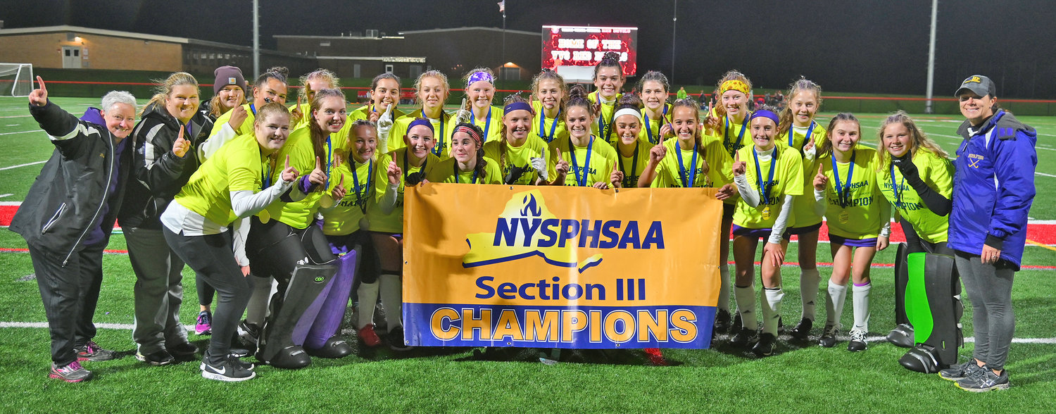 BEST IN CLASS B — The Holland Patent field hockey team poses with their championship banner Sunday evening at Vernon-Verona-Sherrill High School. The team won its fourth Section III title in a row by beating New Hartford 6-0. The school won a Class C title and has since won three Class B championships.