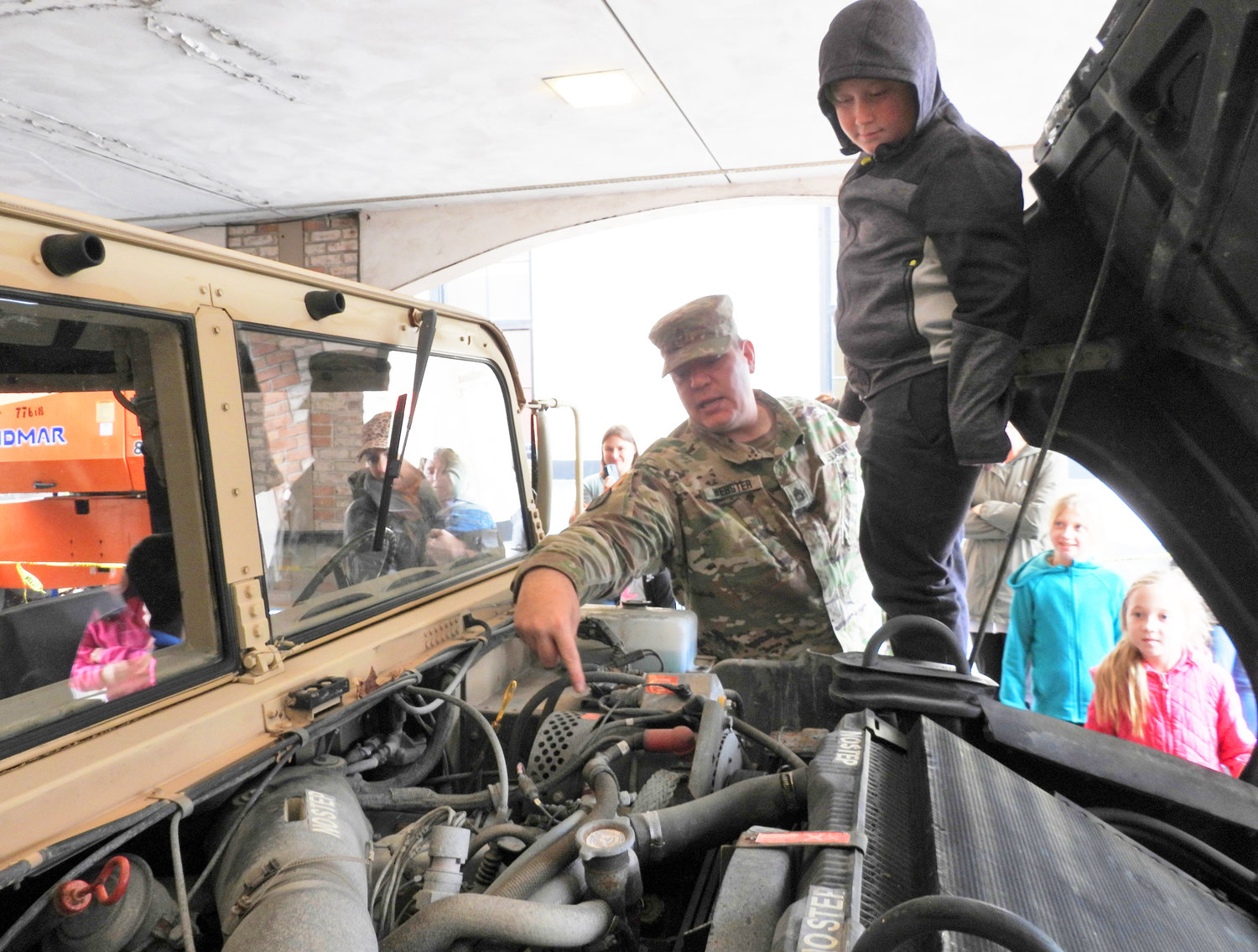 UNDER THE HOOD — A group of curious kids get the opportunity to look under the hood of a military Humvee during a recent demonstration for the homeschooling group that meets at Redeemer Church in Rome.
